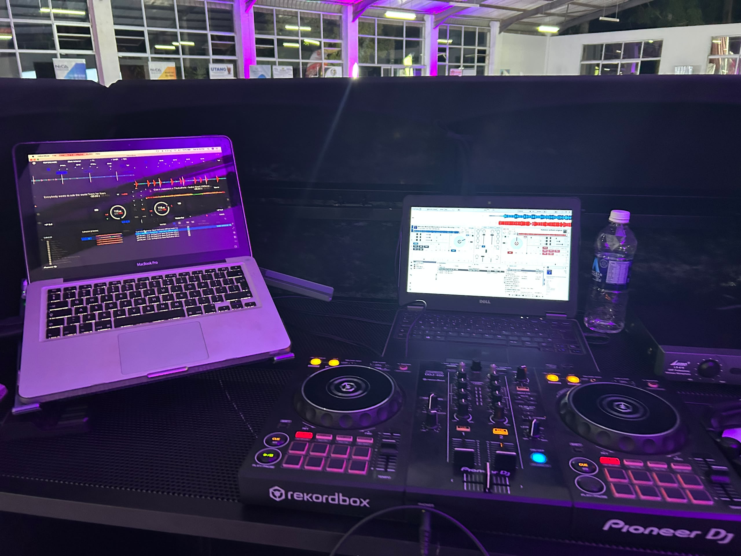 Dual DJ and audio production control setup with MacBook, Pioneer equipment, and monitors