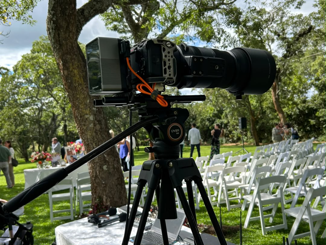 Professional outdoor wedding cinematography with video equipment overlooking scenic venue