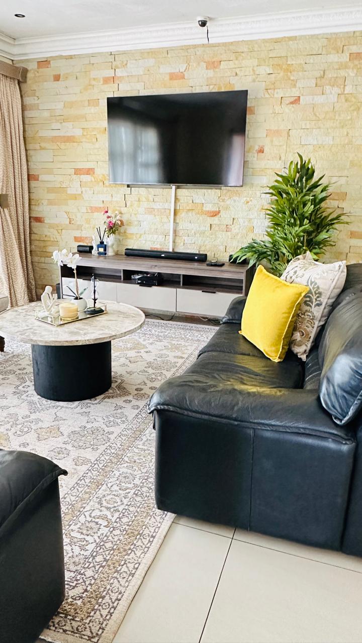 Lounge with leather sofa, feature stone wall and flat-screen TV