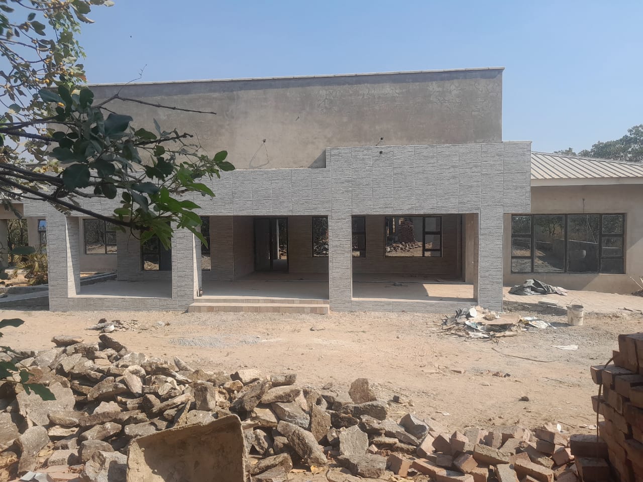 Building facade — grey tiled exterior cladding on large shopfront-style structure under construction