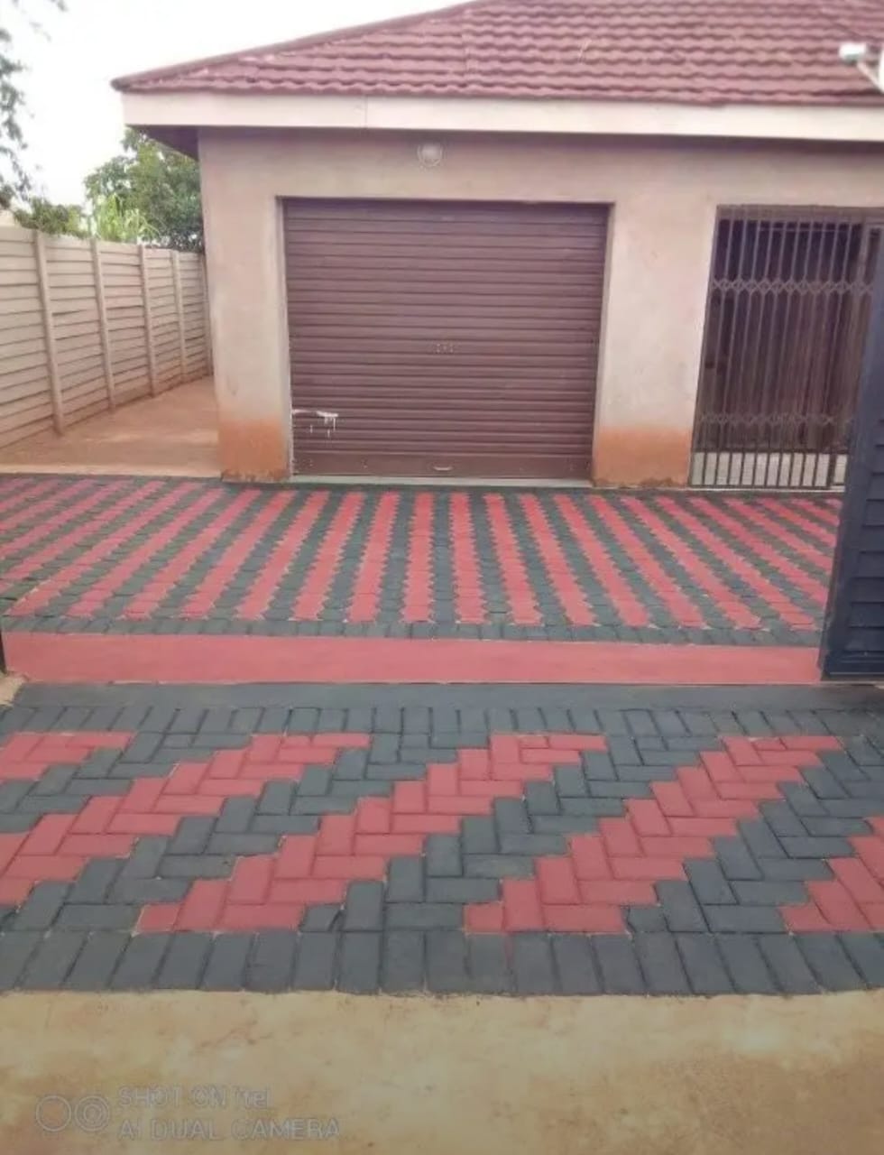 Paving — red and charcoal interlocking brick driveway with chevron pattern