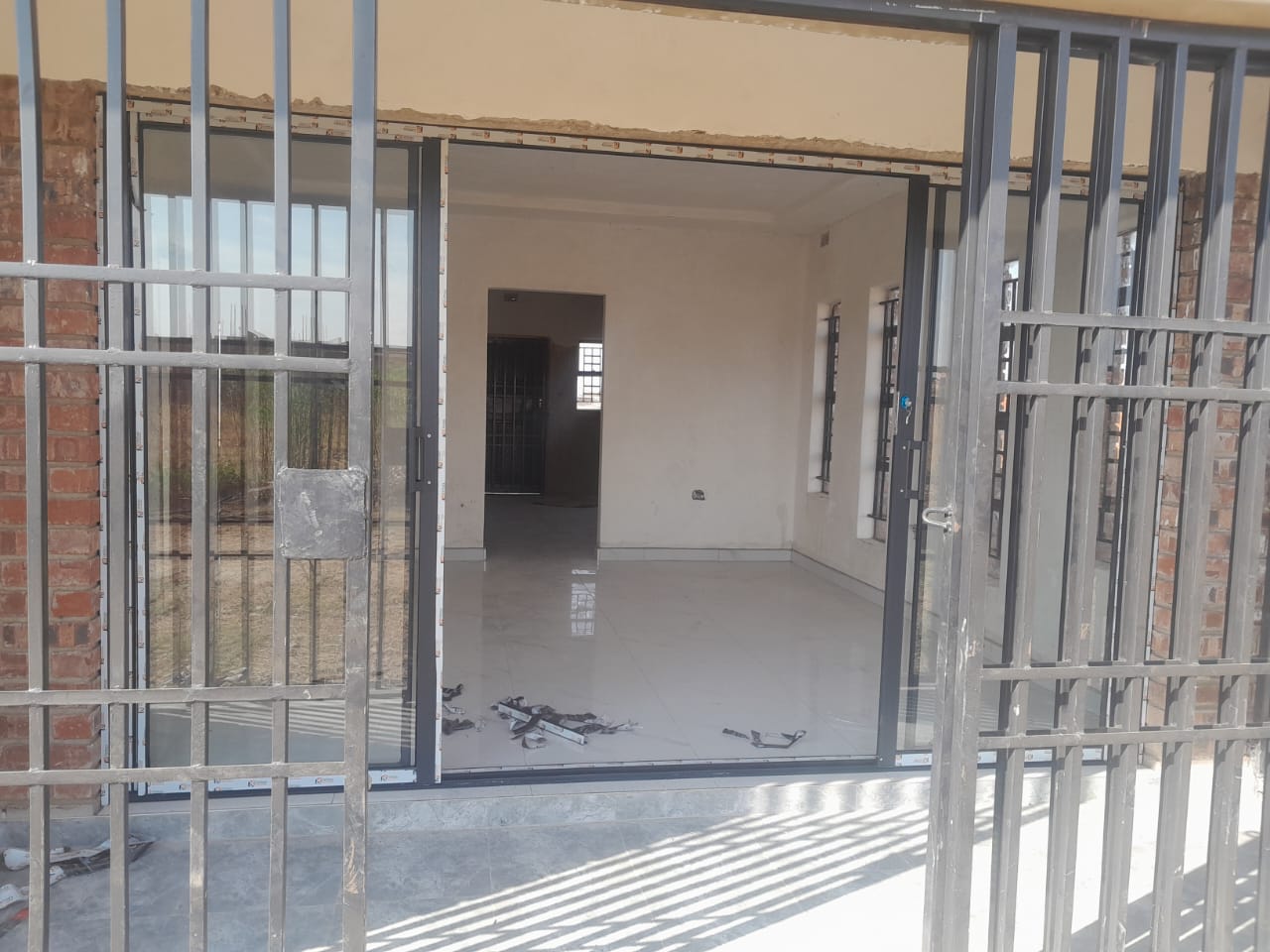 Interior finishing — aluminium security gate and tiled floor, plastered walls