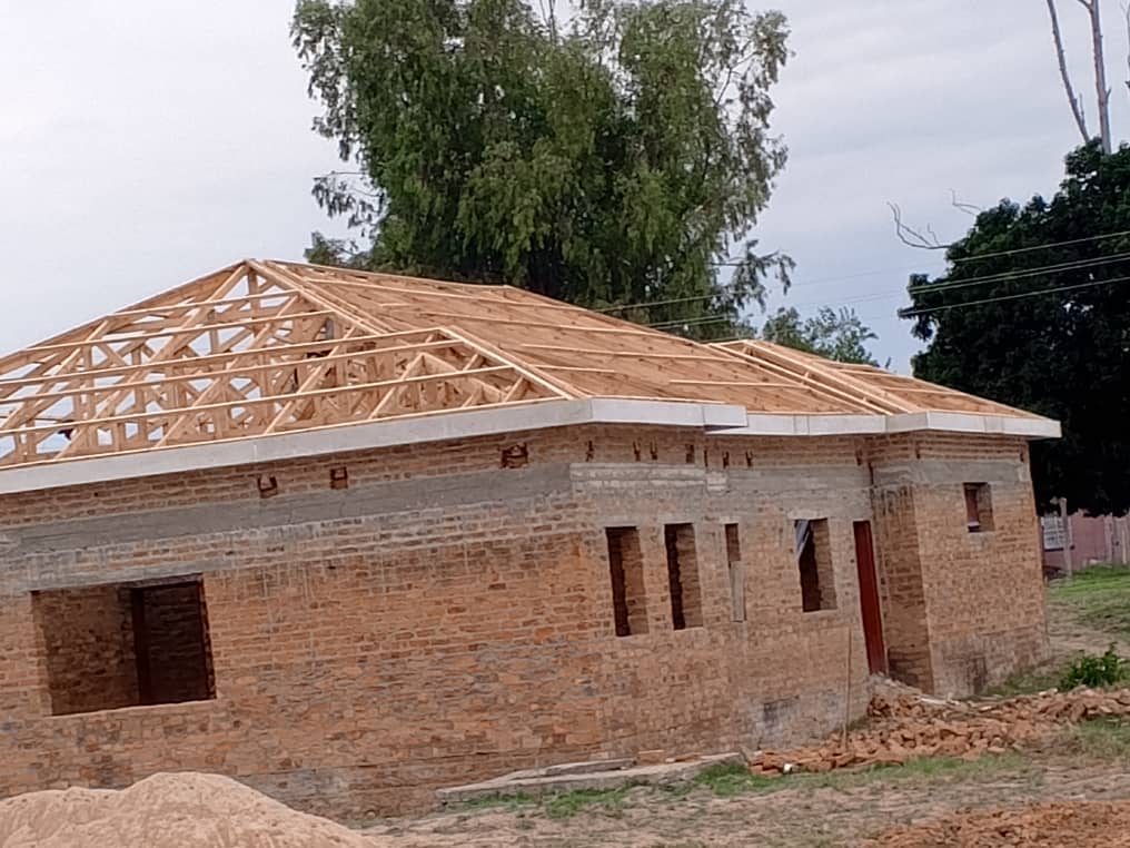 Roofing — single-storey brick house with hip wooden roof trusses under construction