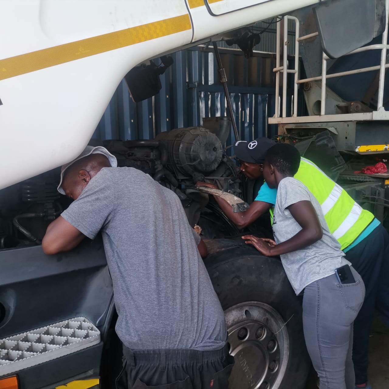 Awomi mechanics servicing a truck engine