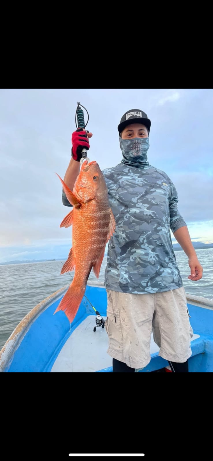 Pescador mostrando un pargo rojo