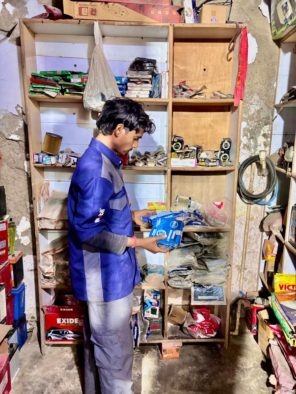 Mechanic checking genuine two-wheeler spare parts