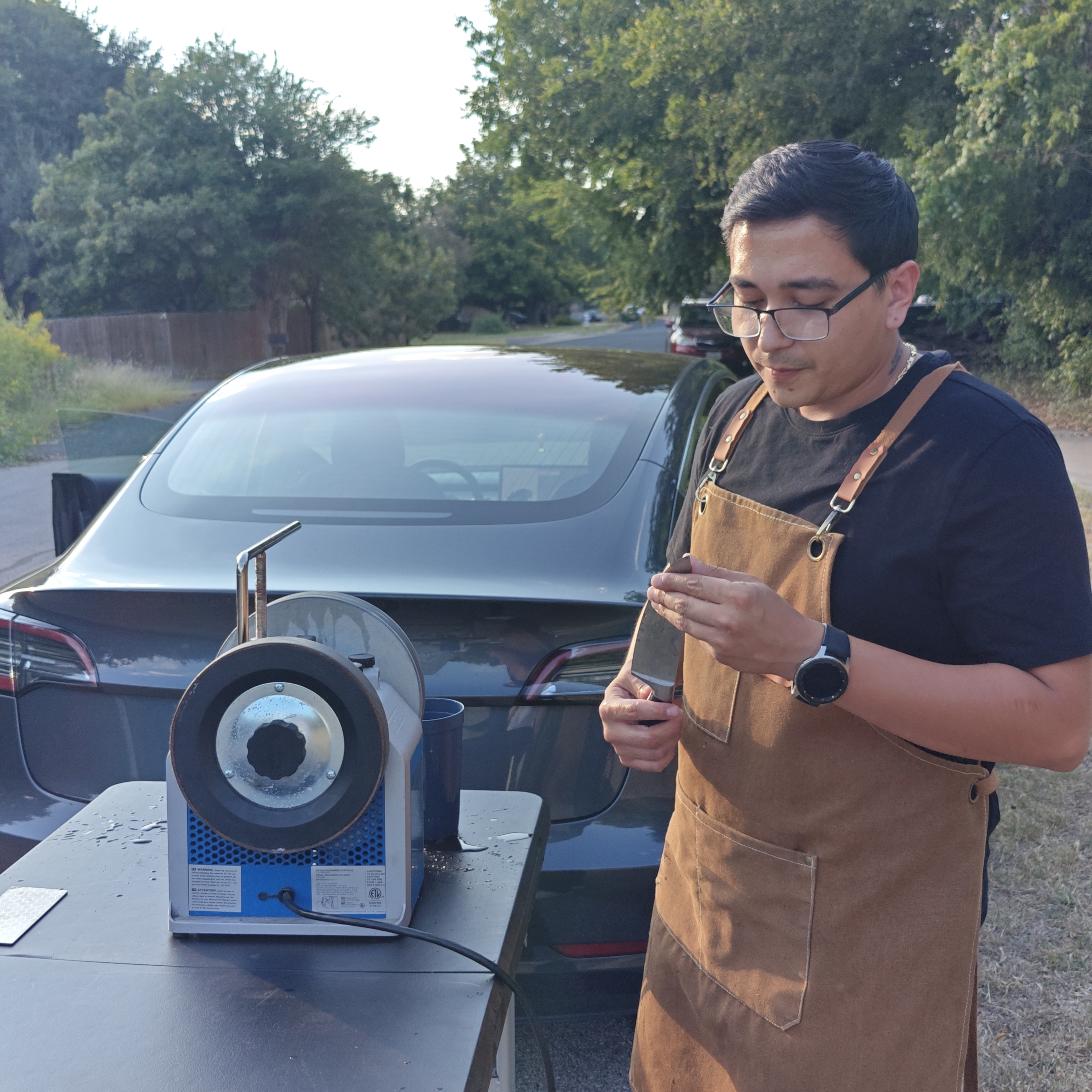 Michael inspecting a blade at his outdoor sharpening station