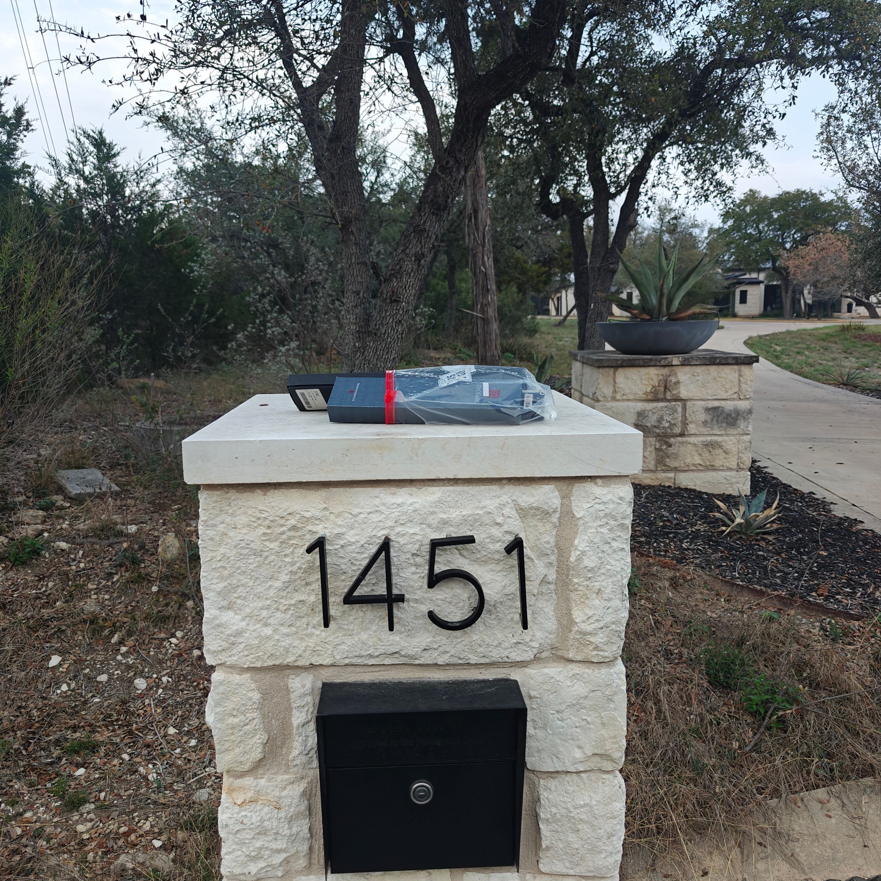 Knives in plastic wrap left on a stone mailbox for porch pickup