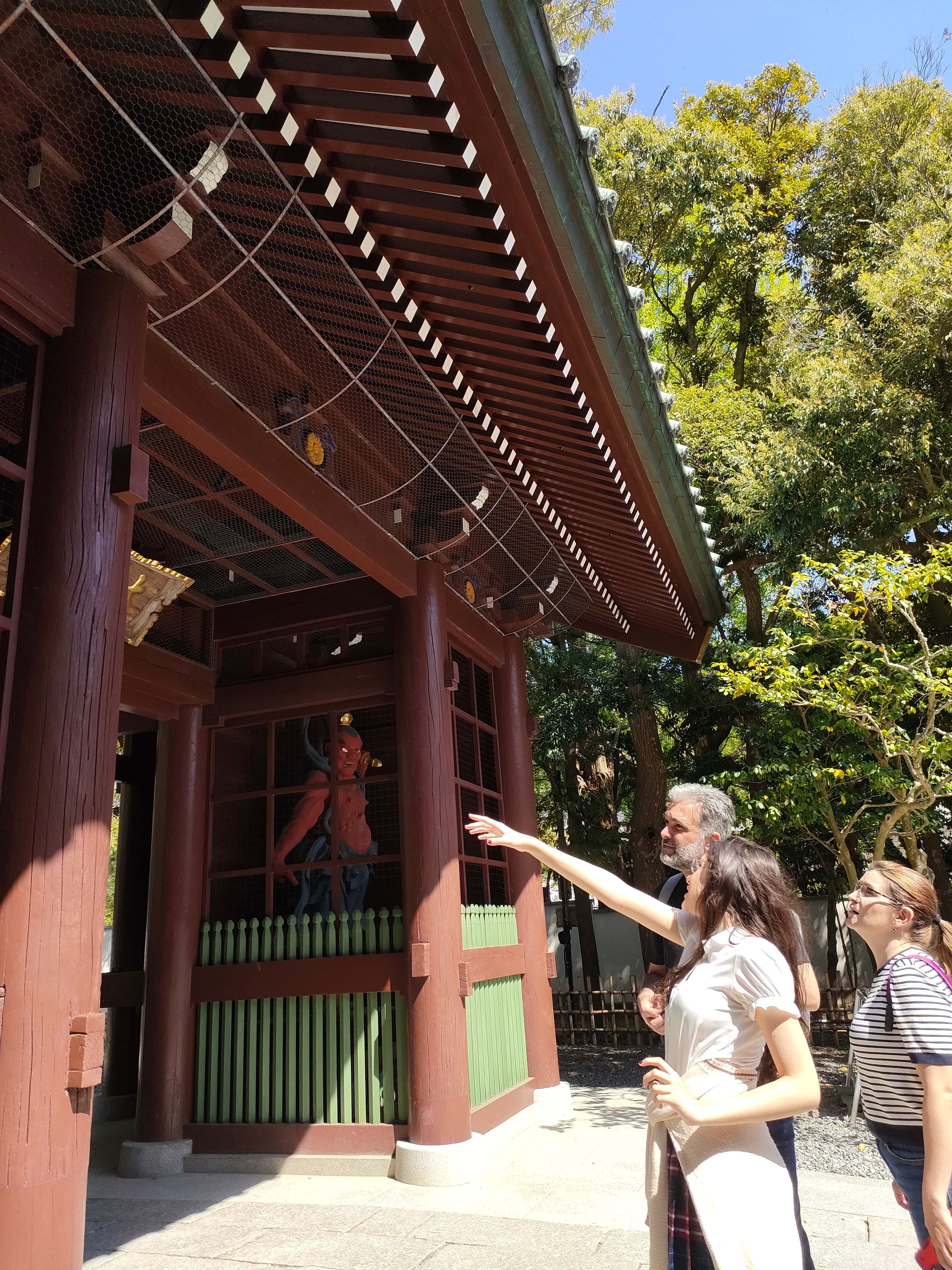 Tour guests admiring the Nio guardian statue at the Great Buddha temple gate