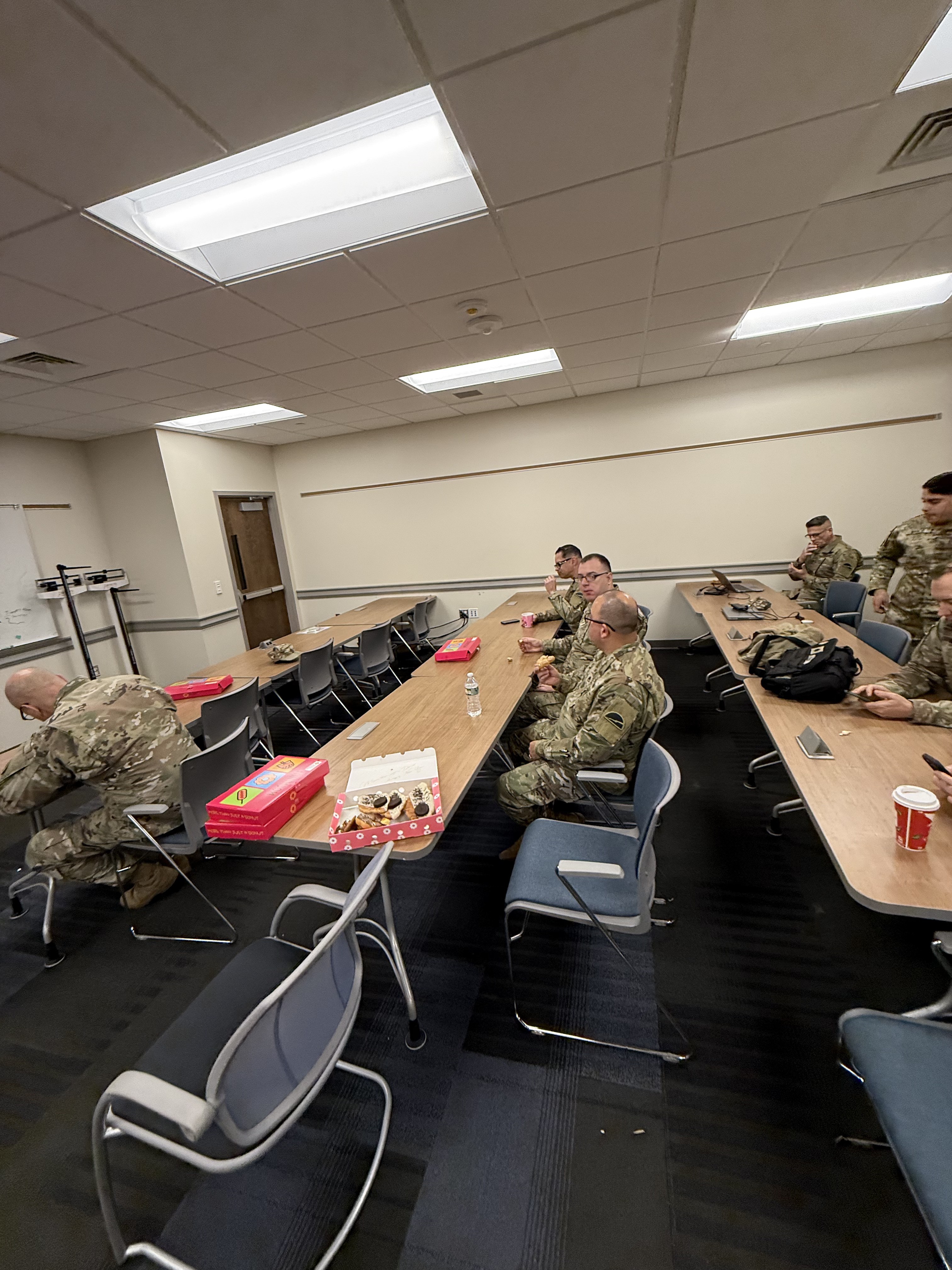 Military service members enjoying Mochinut donuts during a meeting