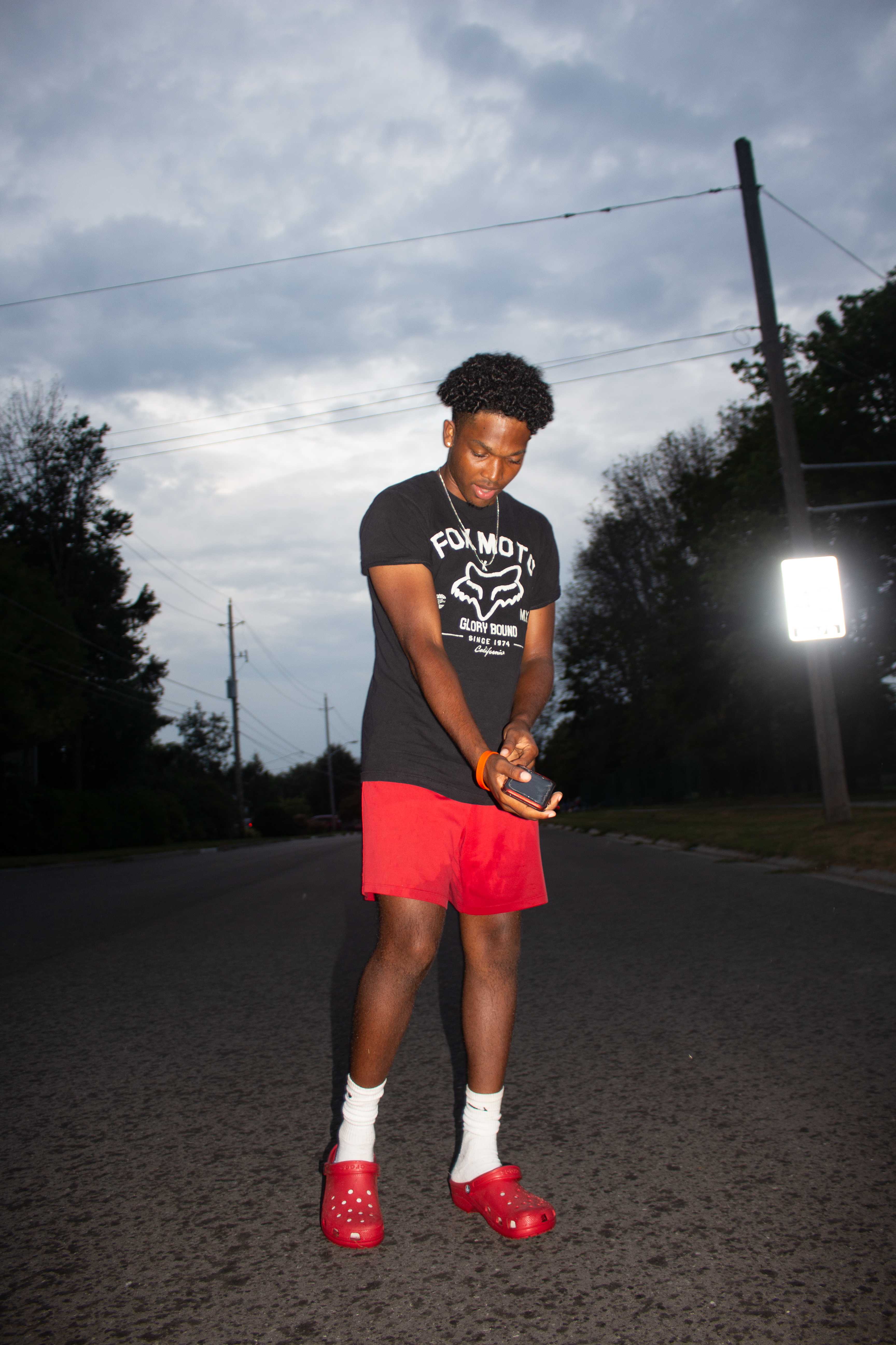 Young man standing on street at dusk