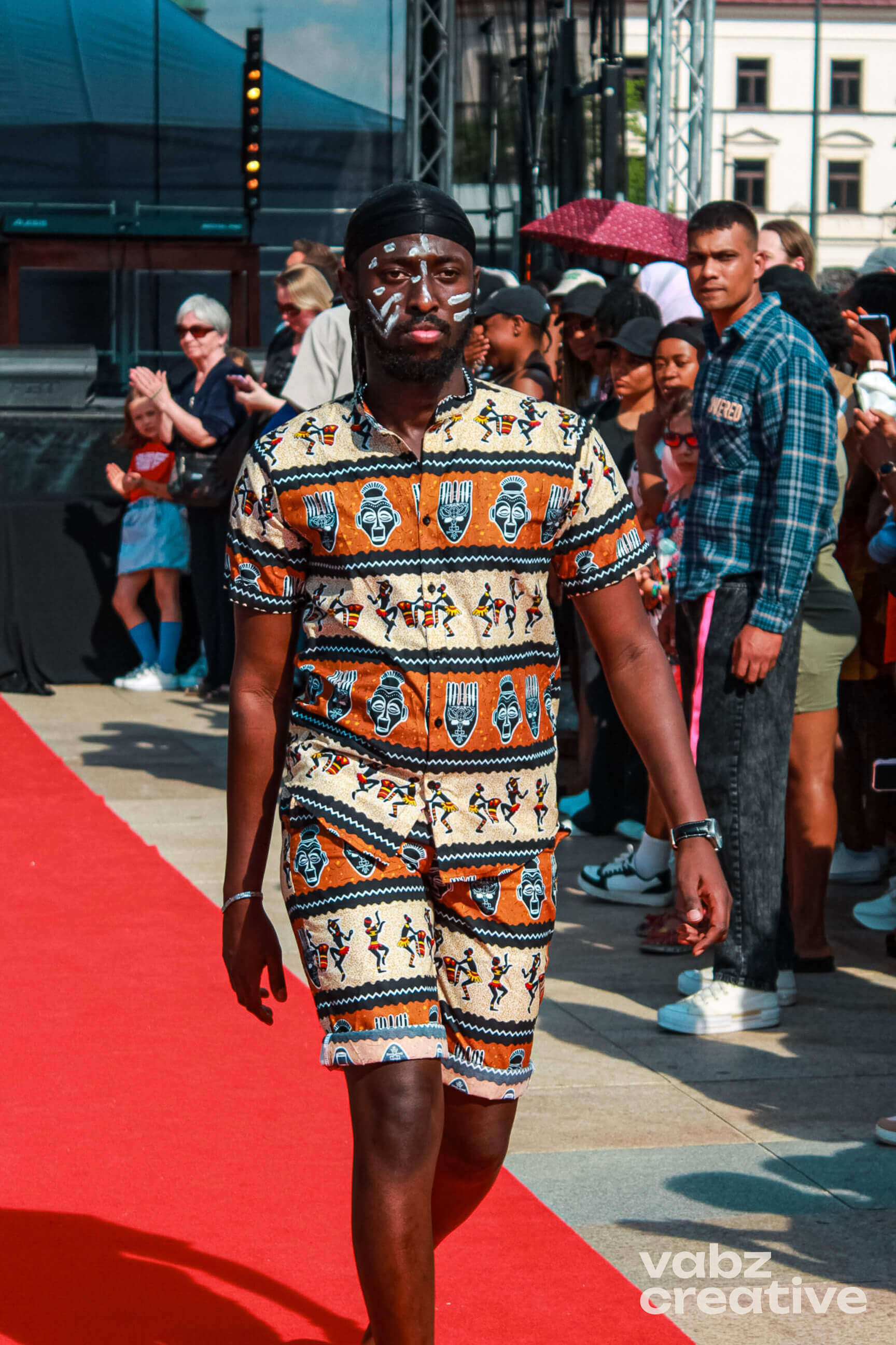 Man with face paint in patterned outfit