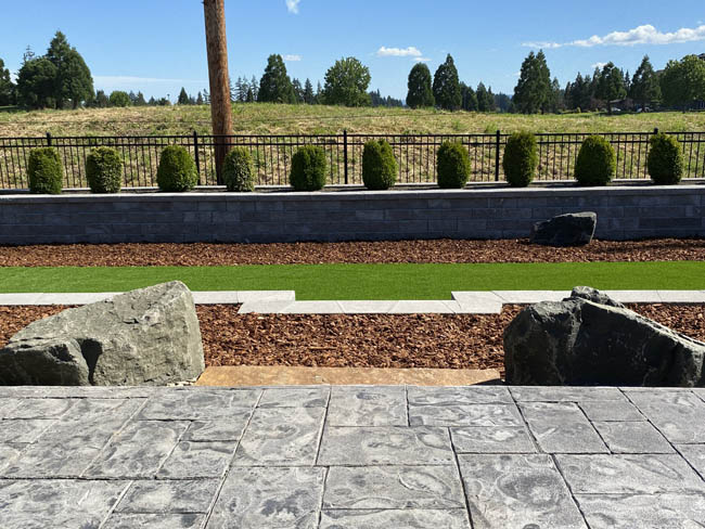 Stamped concrete patio overlooking stacked stone retaining wall