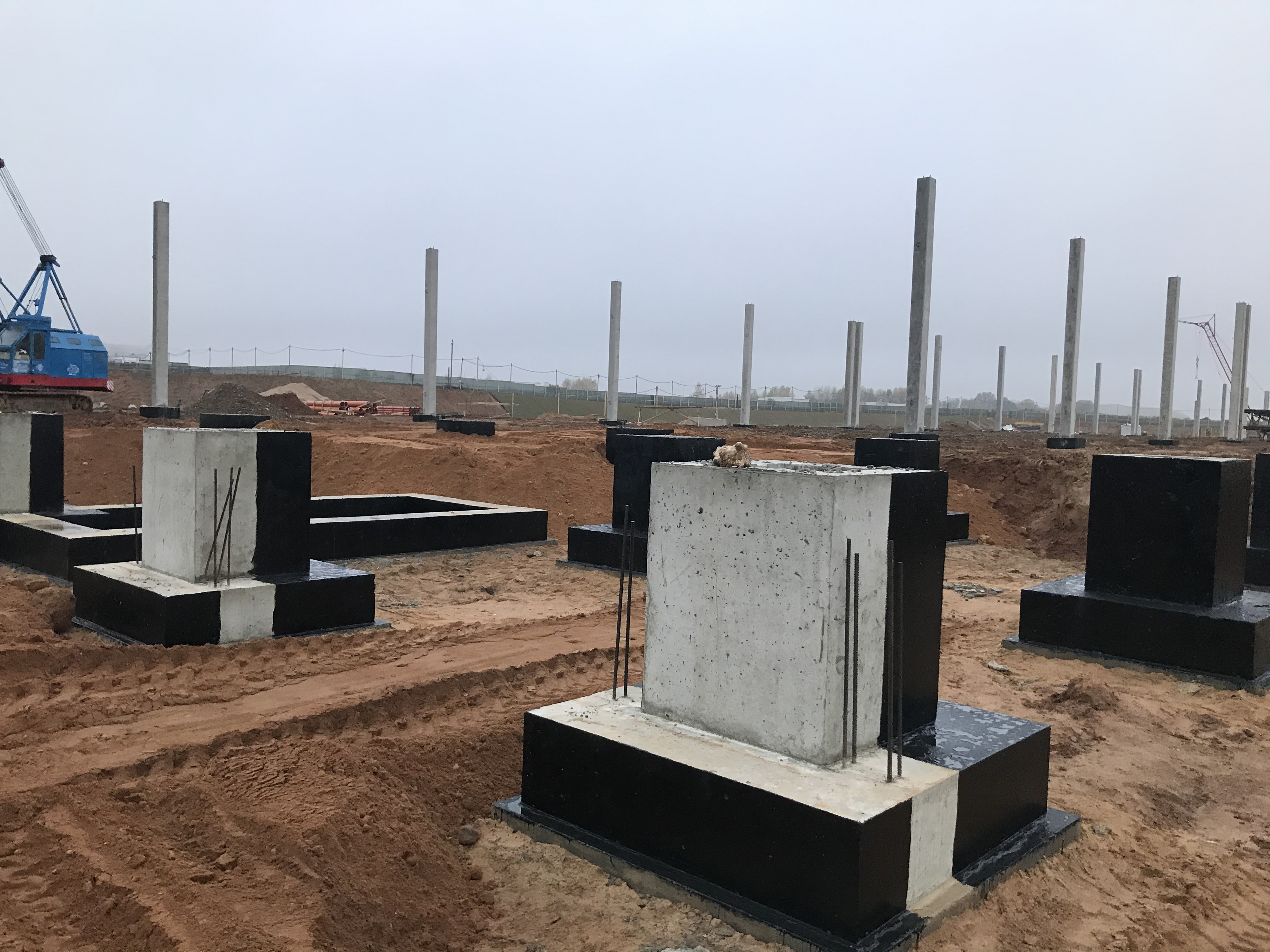 Large-scale foundation construction with concrete piers and crane
