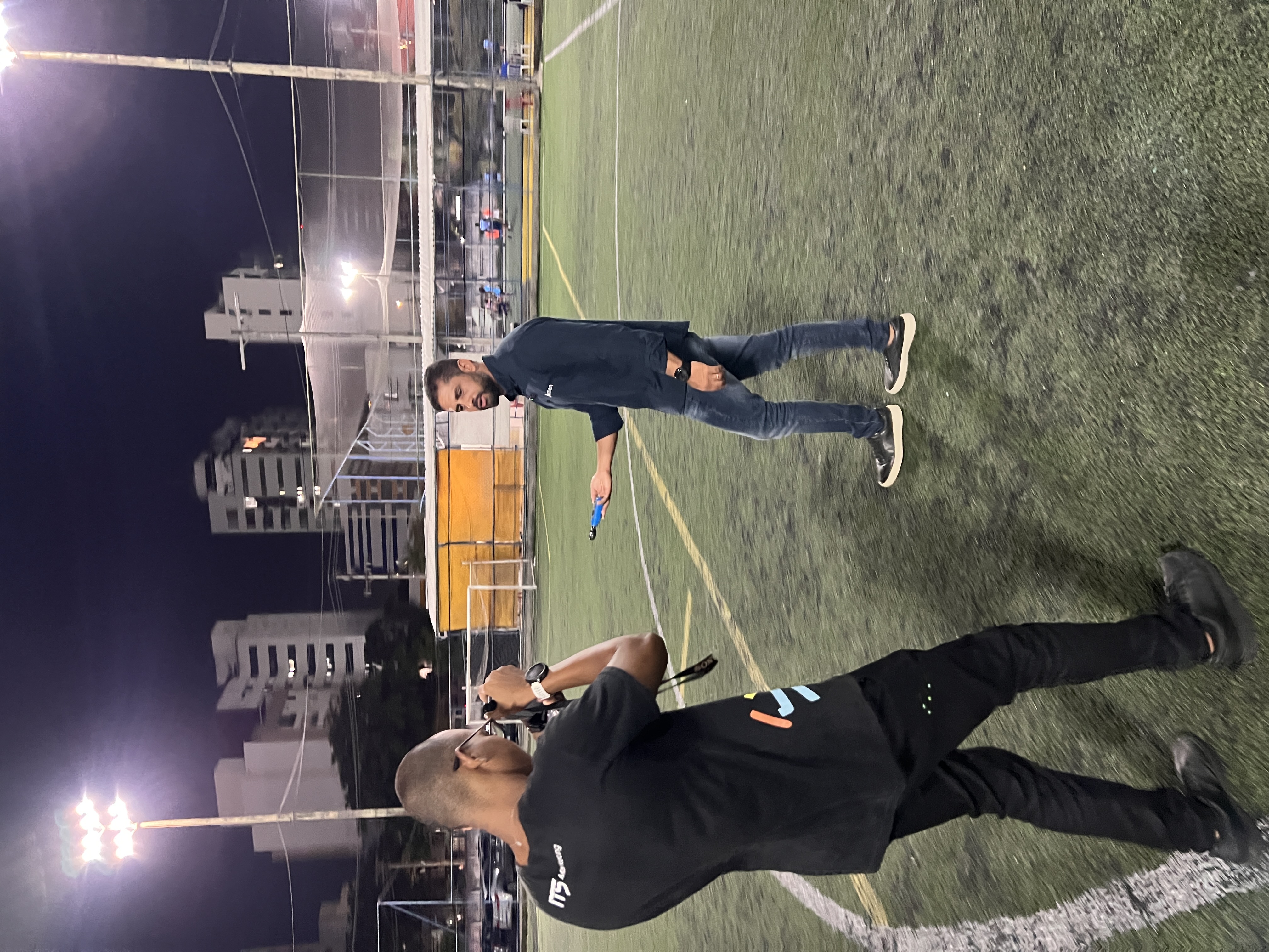 Ítalo filmando cliente em campo de futebol à noite