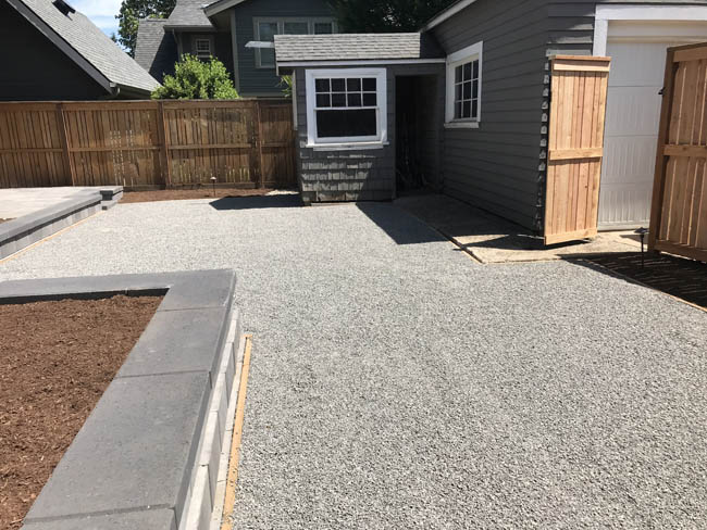 Gravel parking pad with stacked-block retaining wall border
