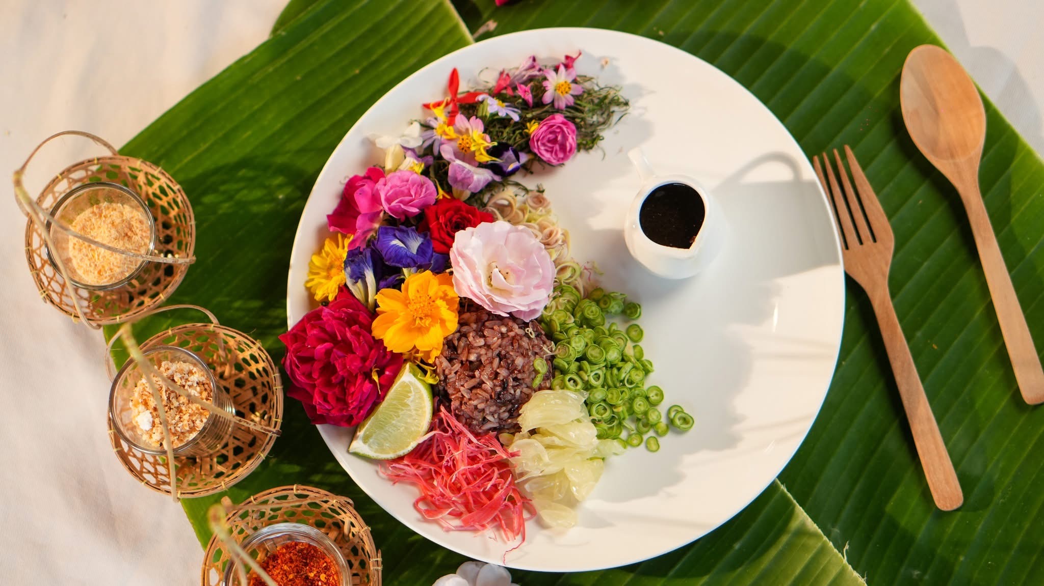 Colorful Thai noodle bowl with edible flowers on banana leaf
