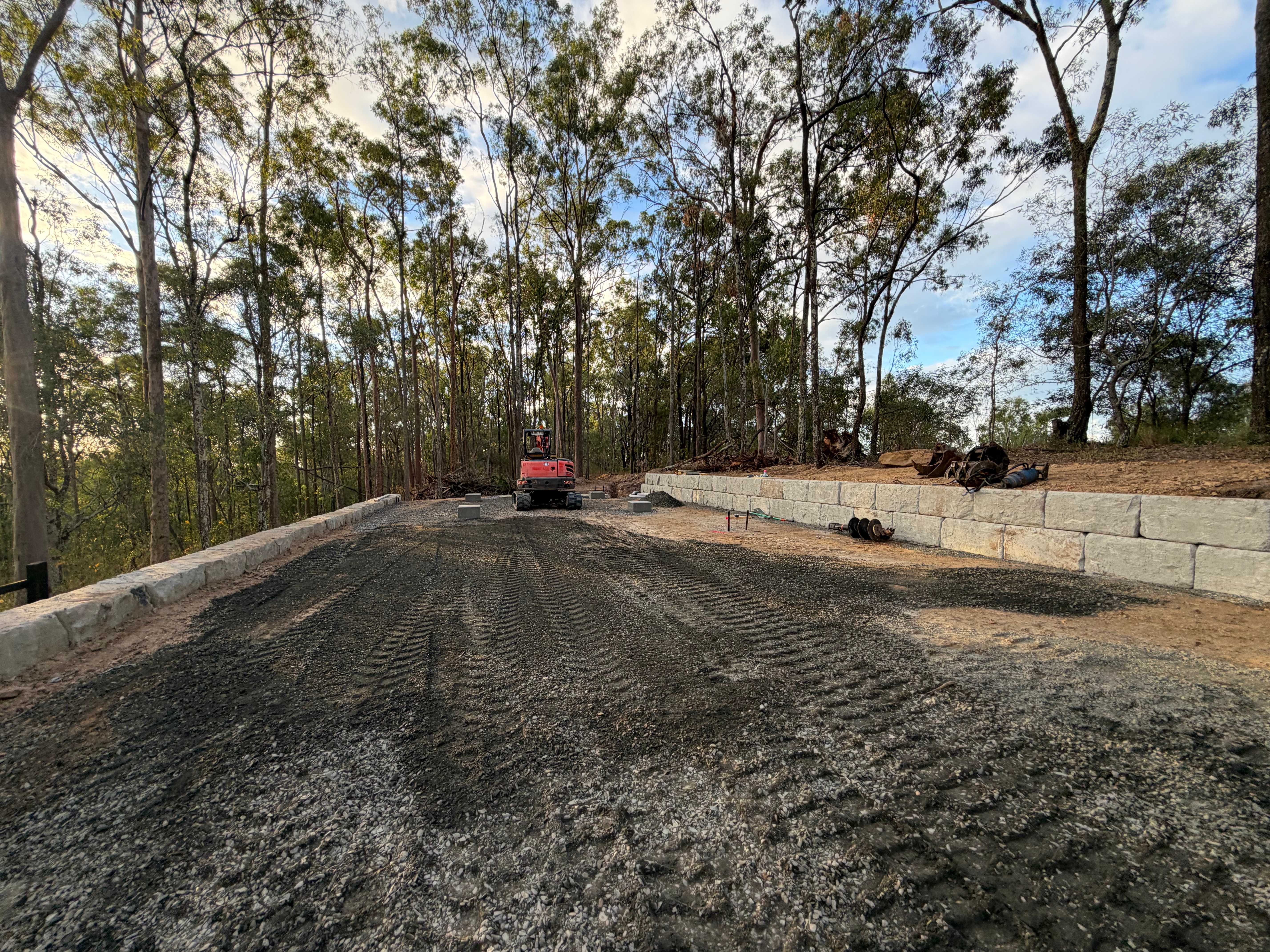 Gravel driveway pad with sandstone retaining walls