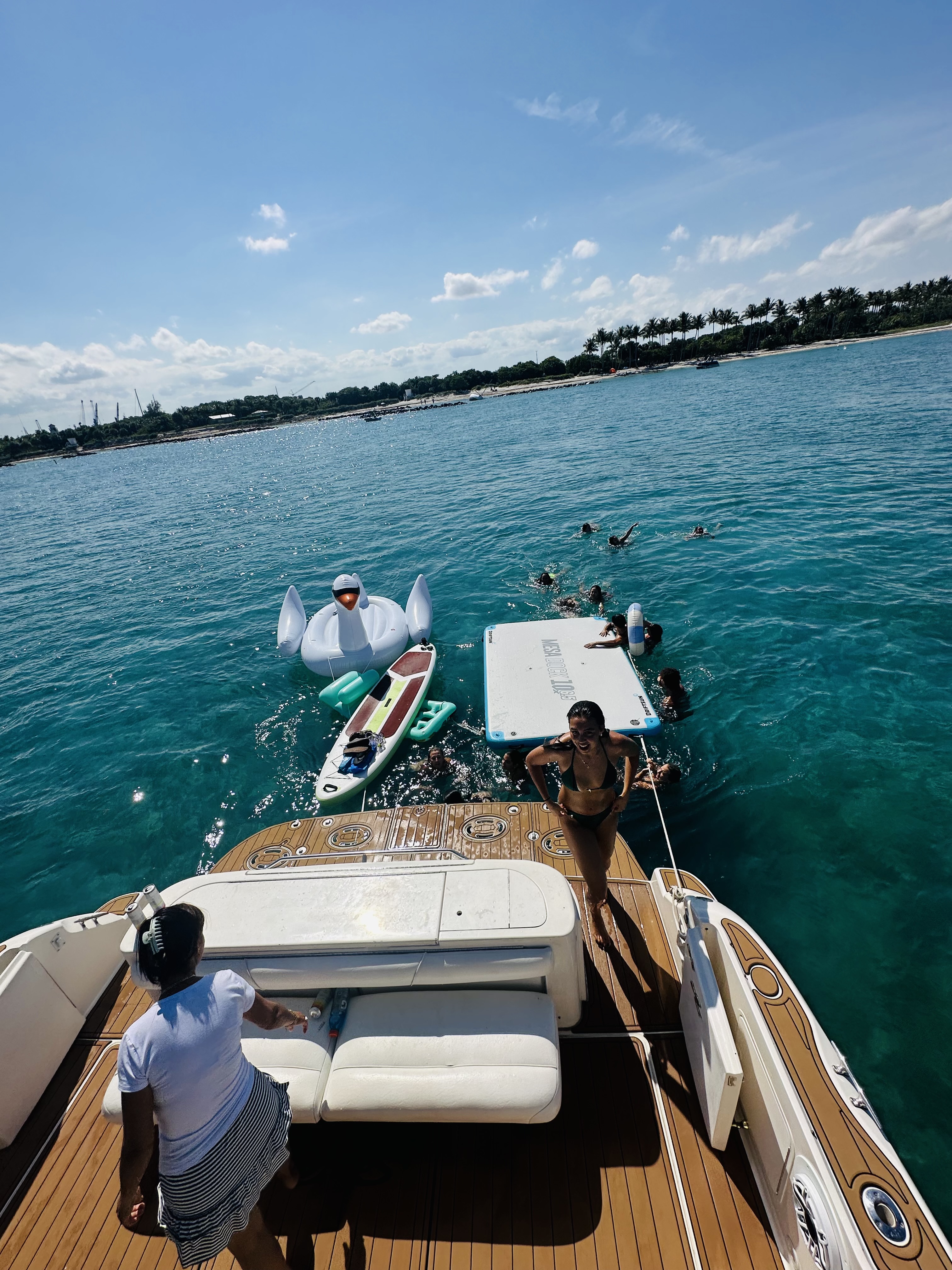 Guests enjoying water toys and floats from the yacht stern