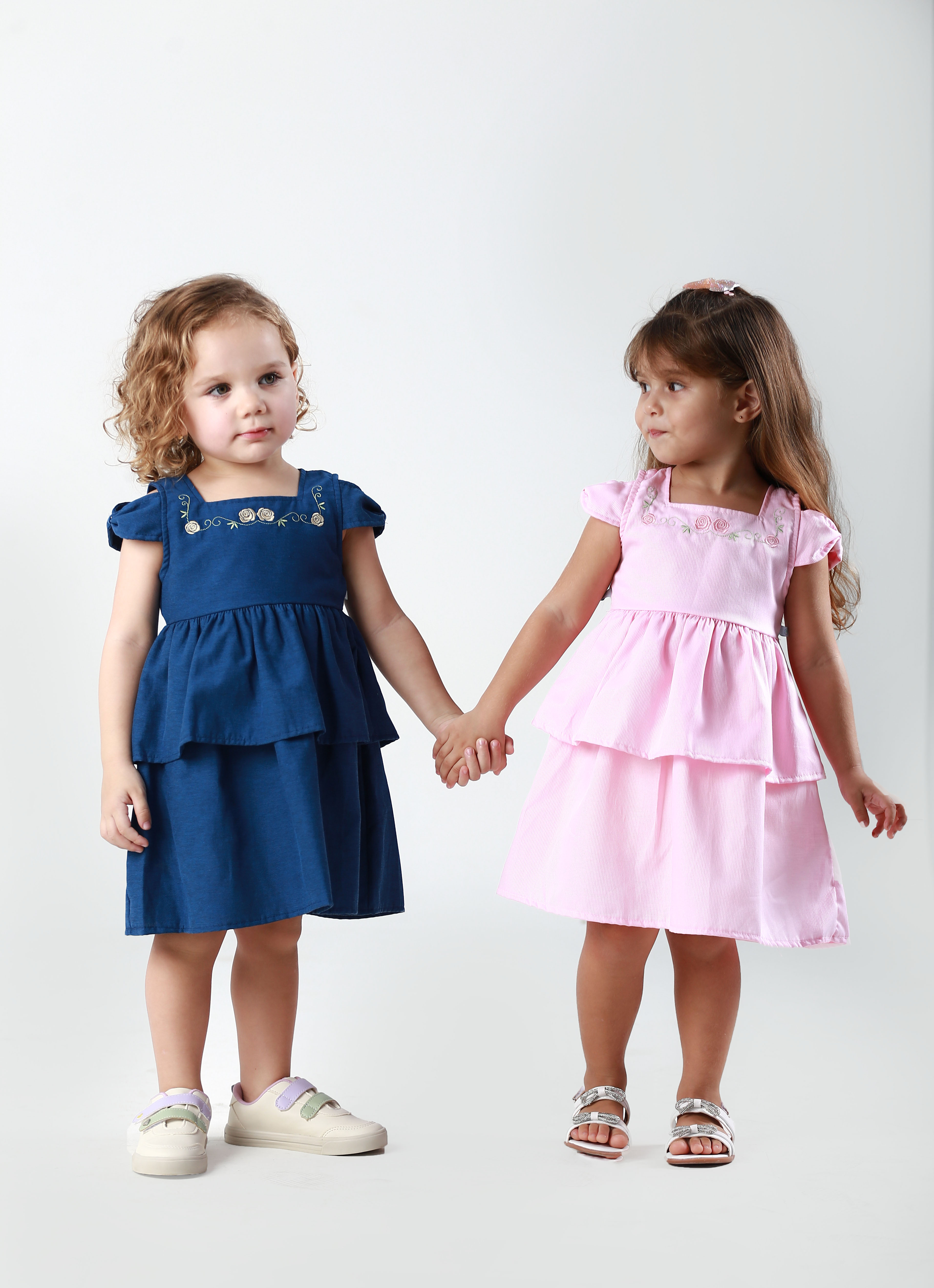 Duas meninas de mãos dadas – vestido azul marinho e rosa