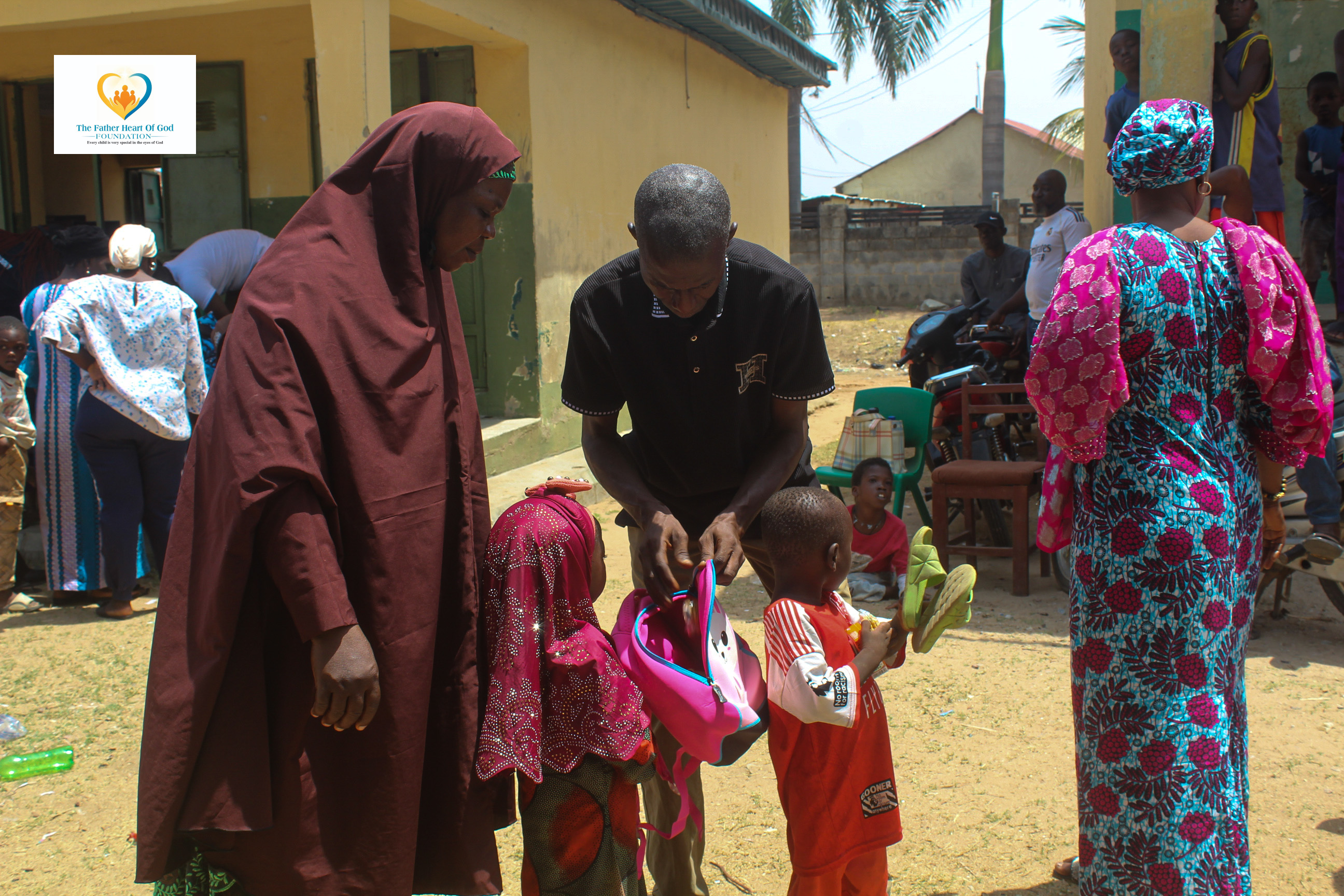 Volunteer distributing backpack to child