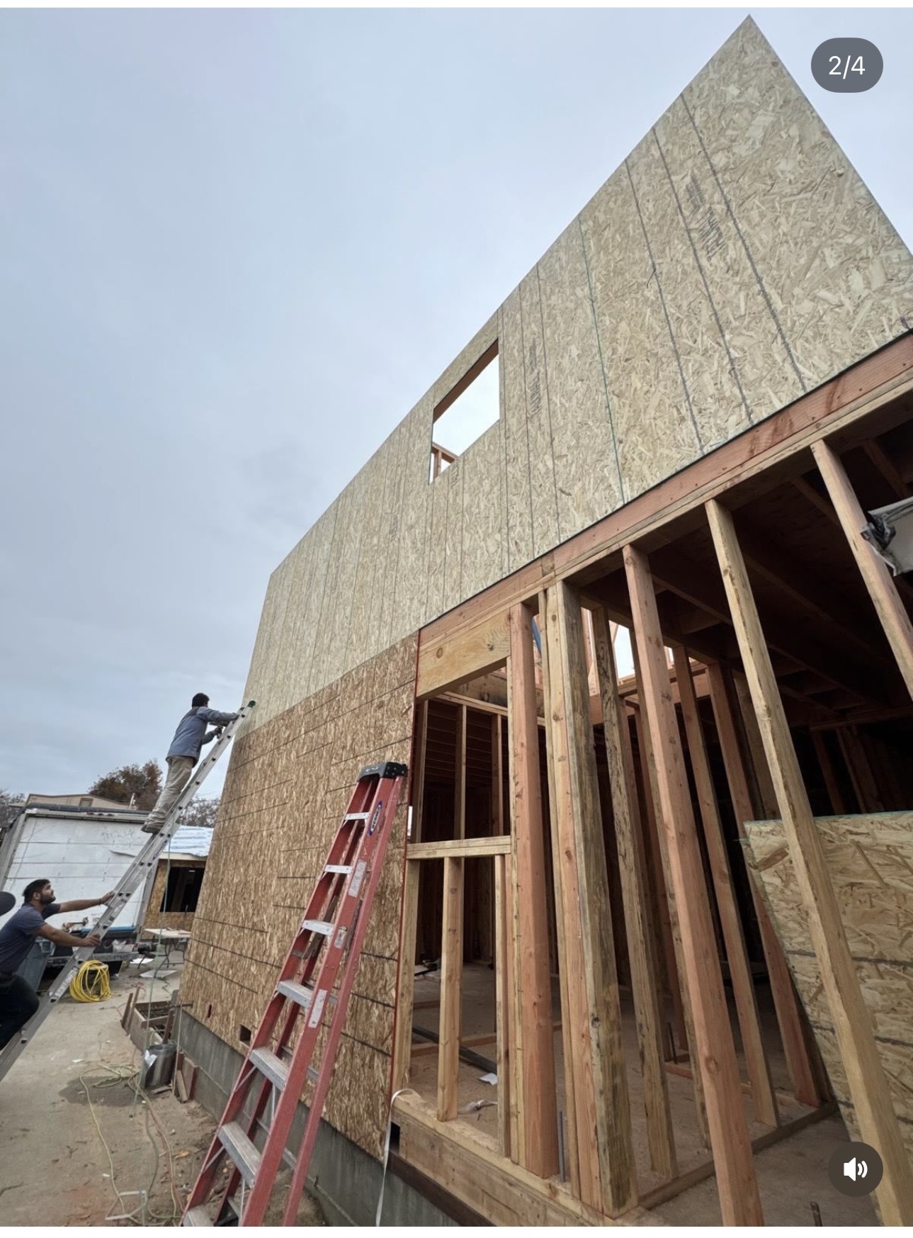 Workers installing sheathing on new construction