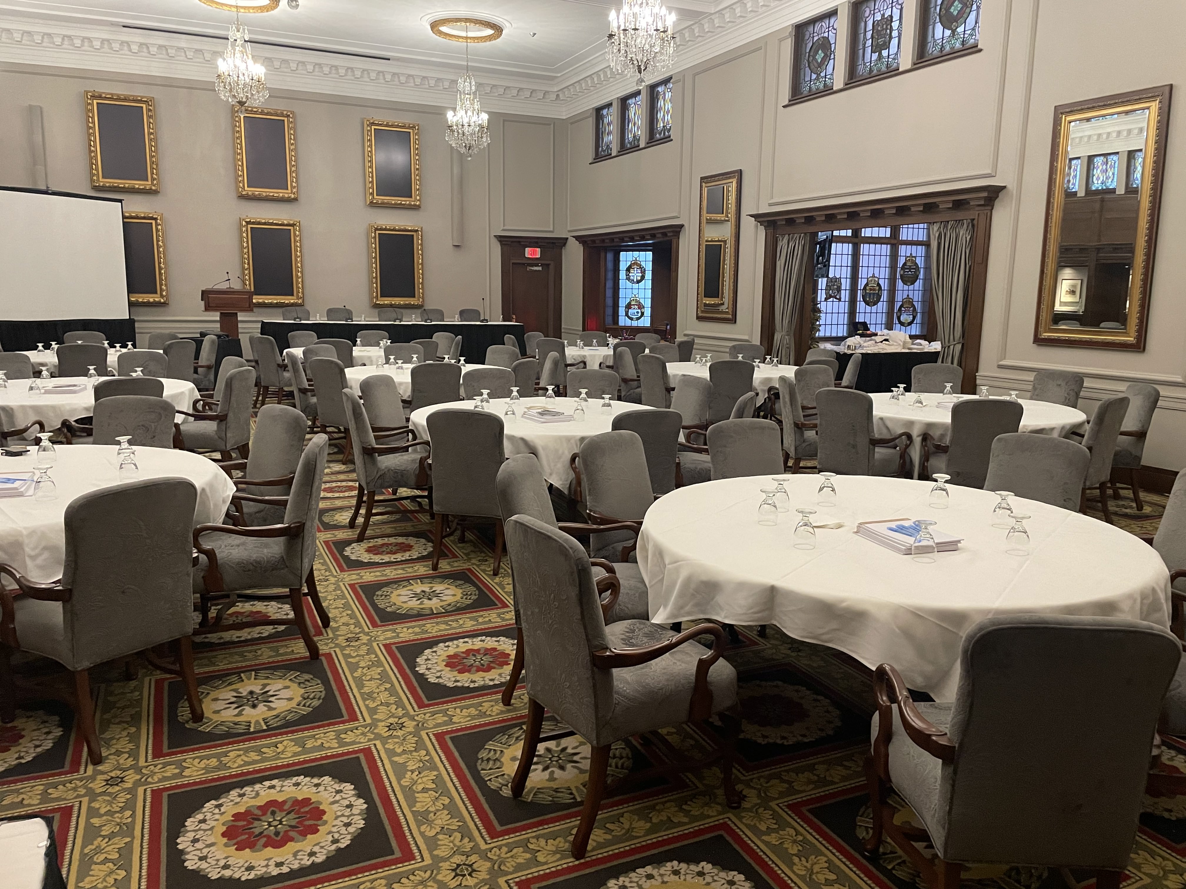 A private dinner venue set with round tables and white linens.