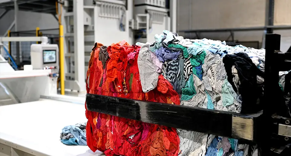 Compressed bale of sorted textiles showing various colored garments ready for secure destruction