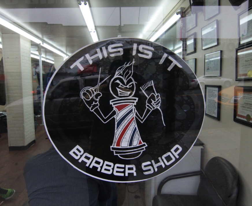 This Is It Barbershop logo on window