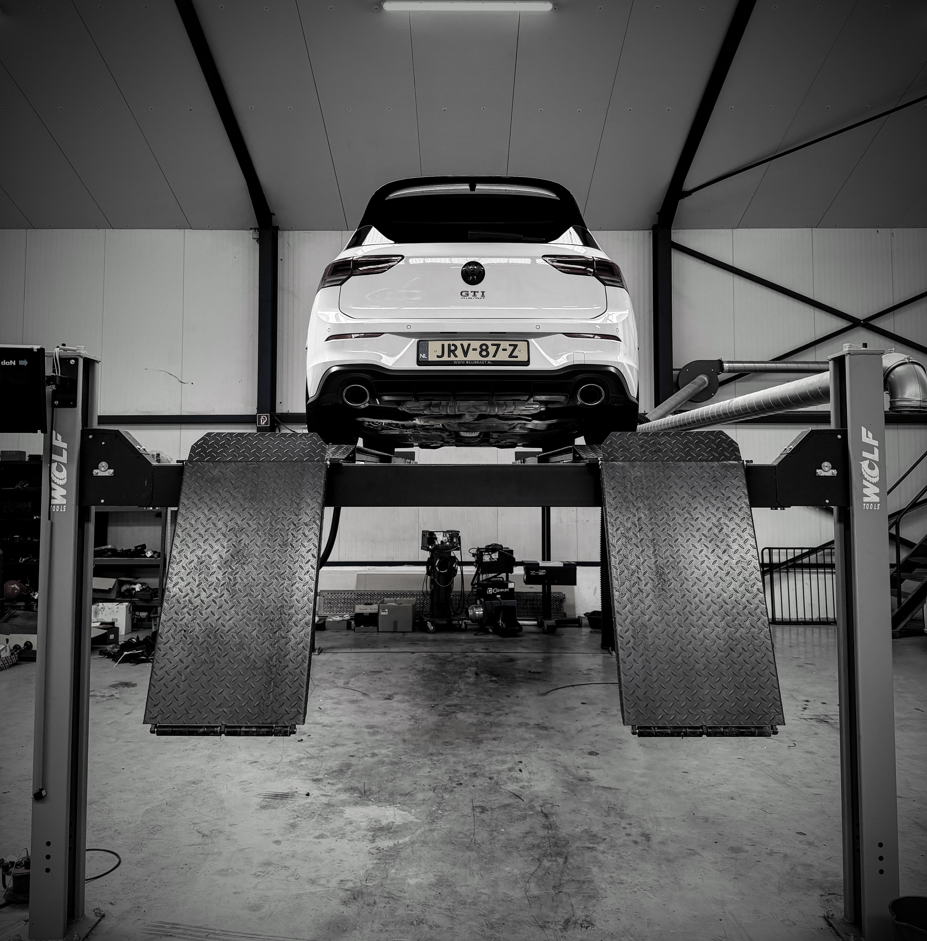 Witte Volkswagen Golf GTI op de hefbrug in de werkplaats