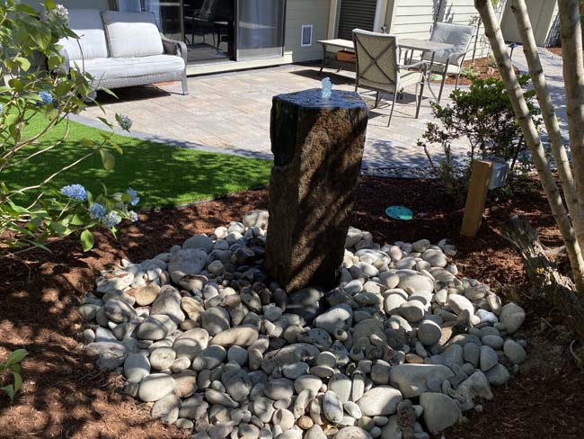 Drilled basalt-column fountain with river-rock catch basin