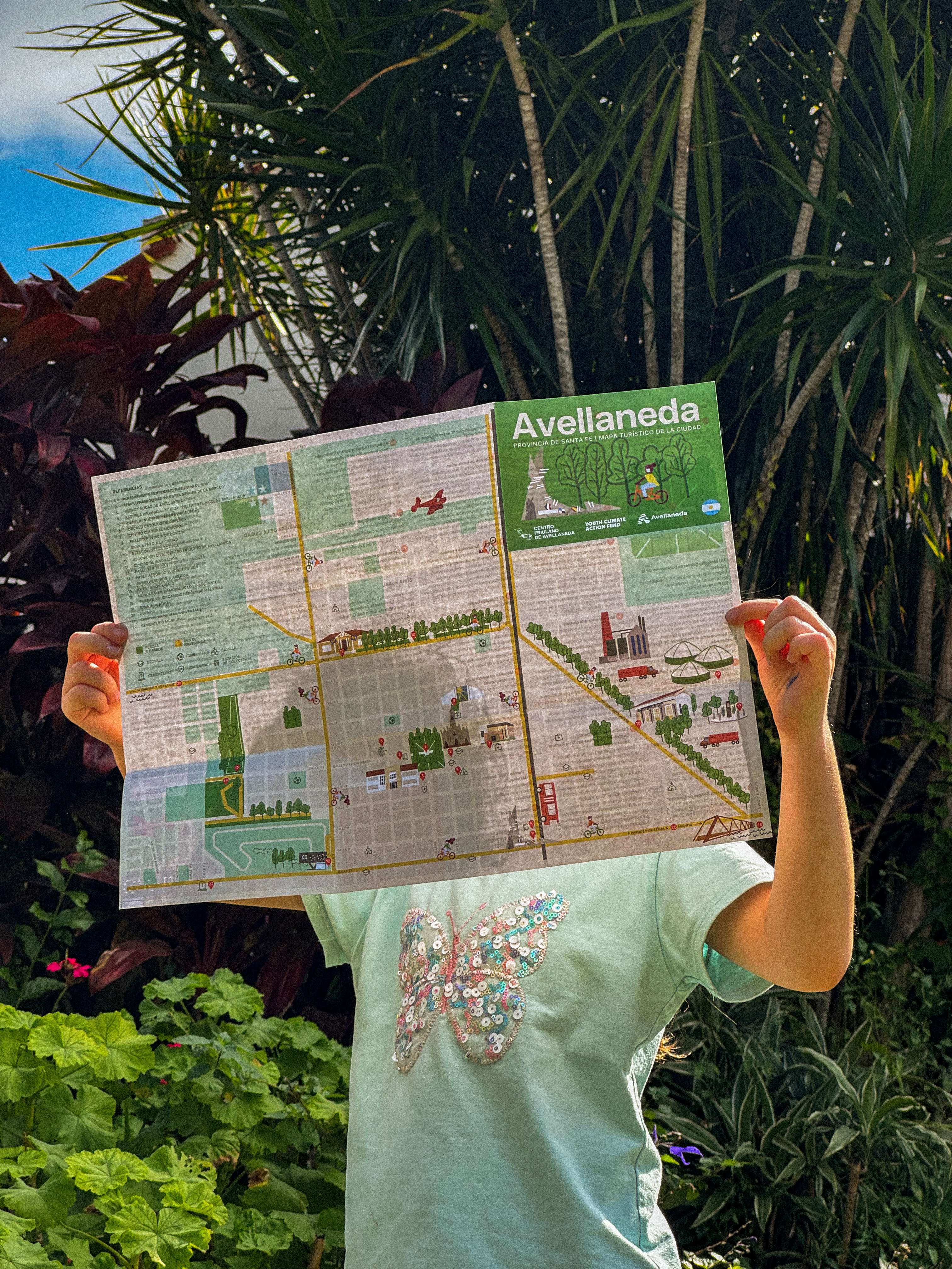Mapa turístico Avellaneda - Niña sosteniendo mapa abierto