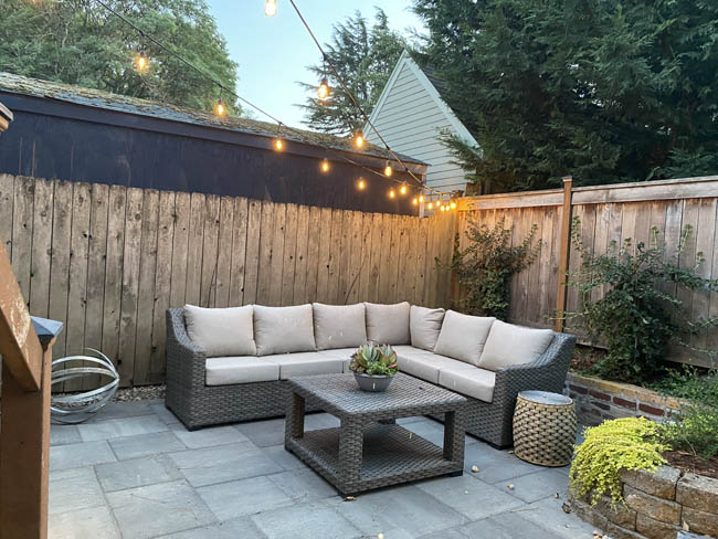 Bluestone patio with sectional and string lights at dusk