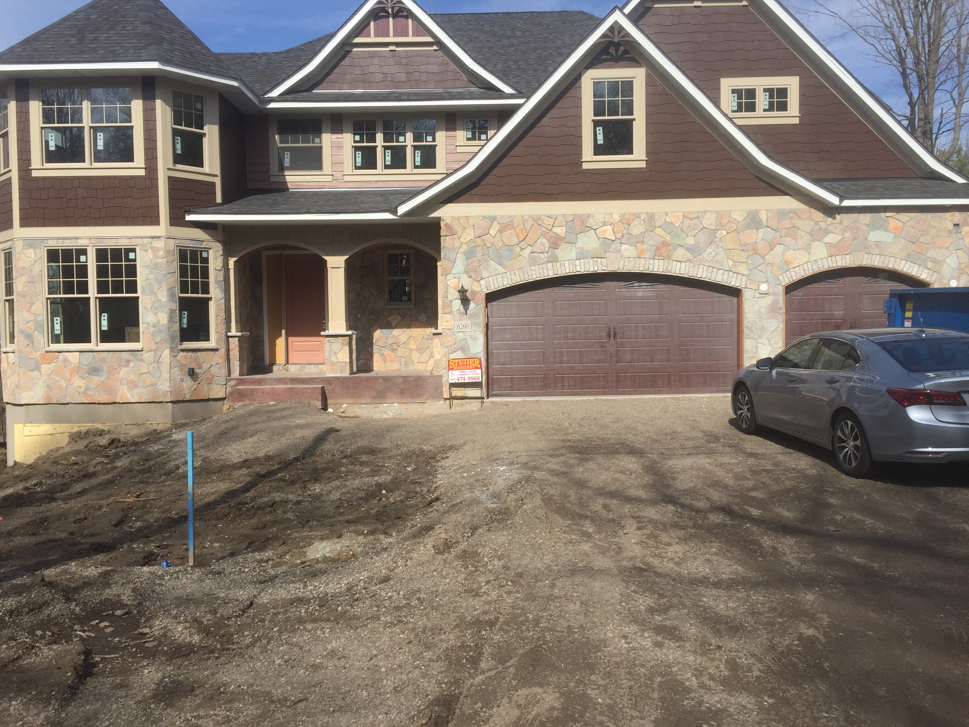 New construction home with full natural fieldstone masonry facade installed by Studer Masonry in Excelsior, MN.