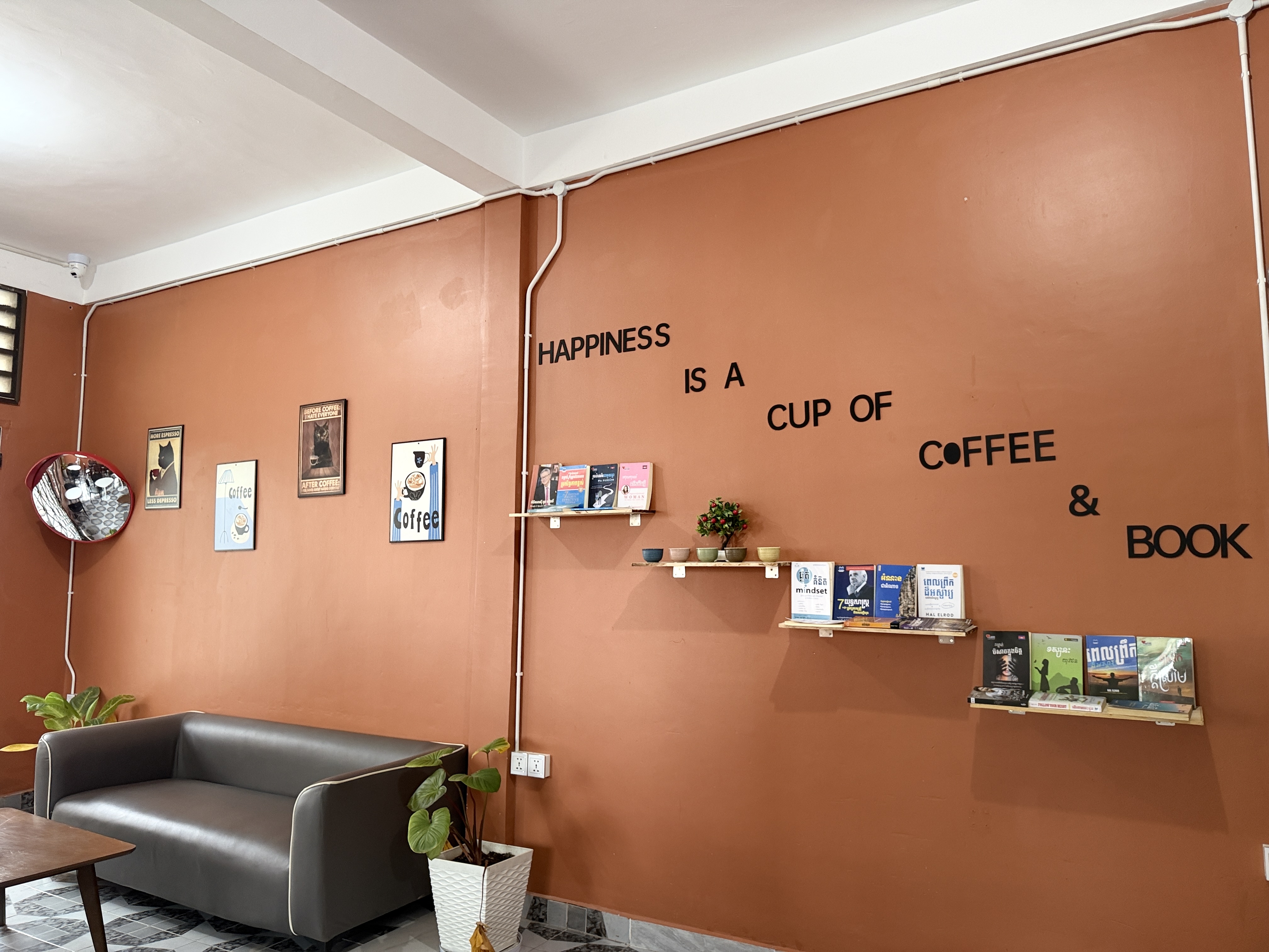 Happiness is a cup of coffee and book wall at Lao Tue Coffee