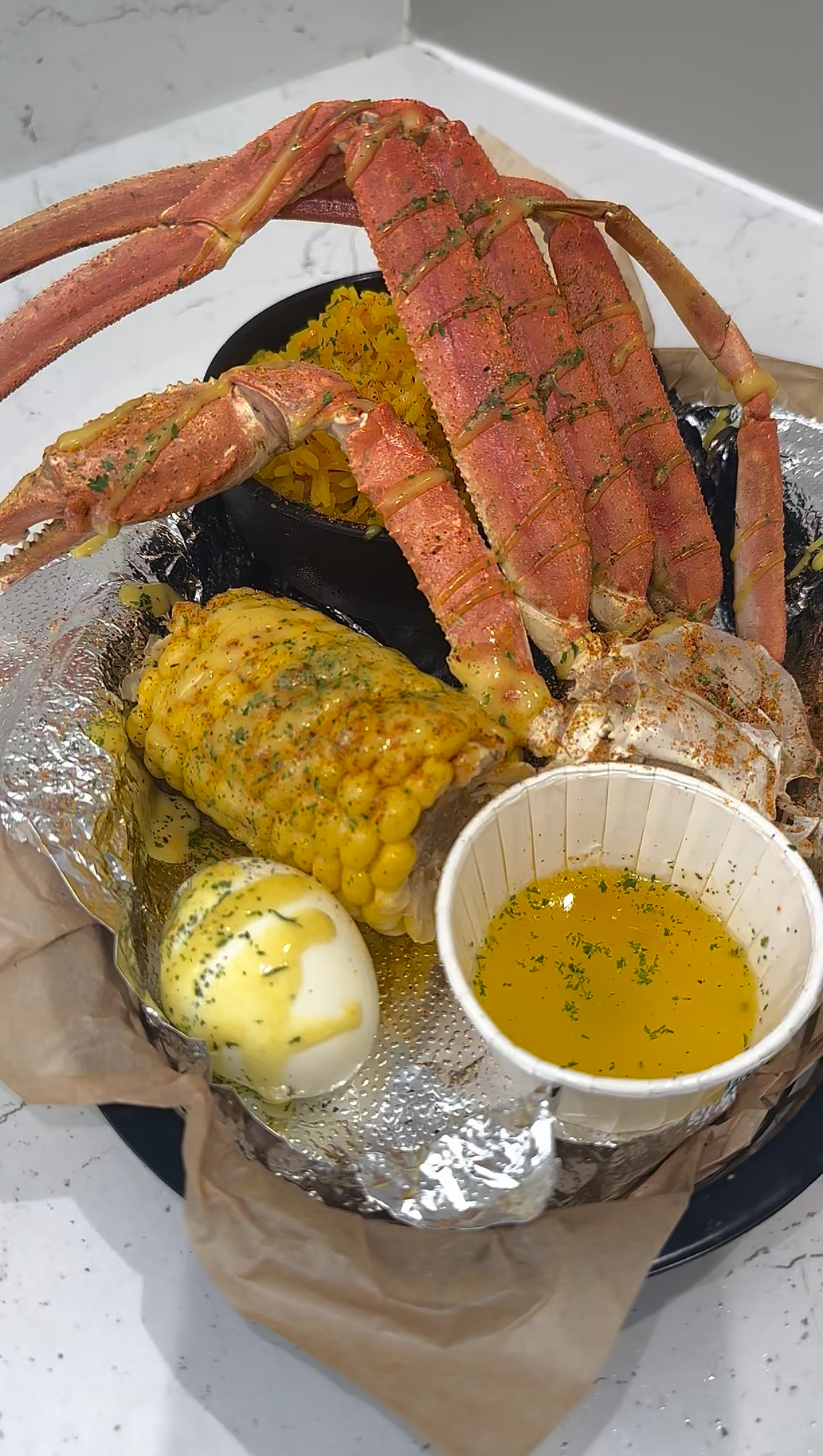 Snow crab legs with corn, egg, and butter sauce
