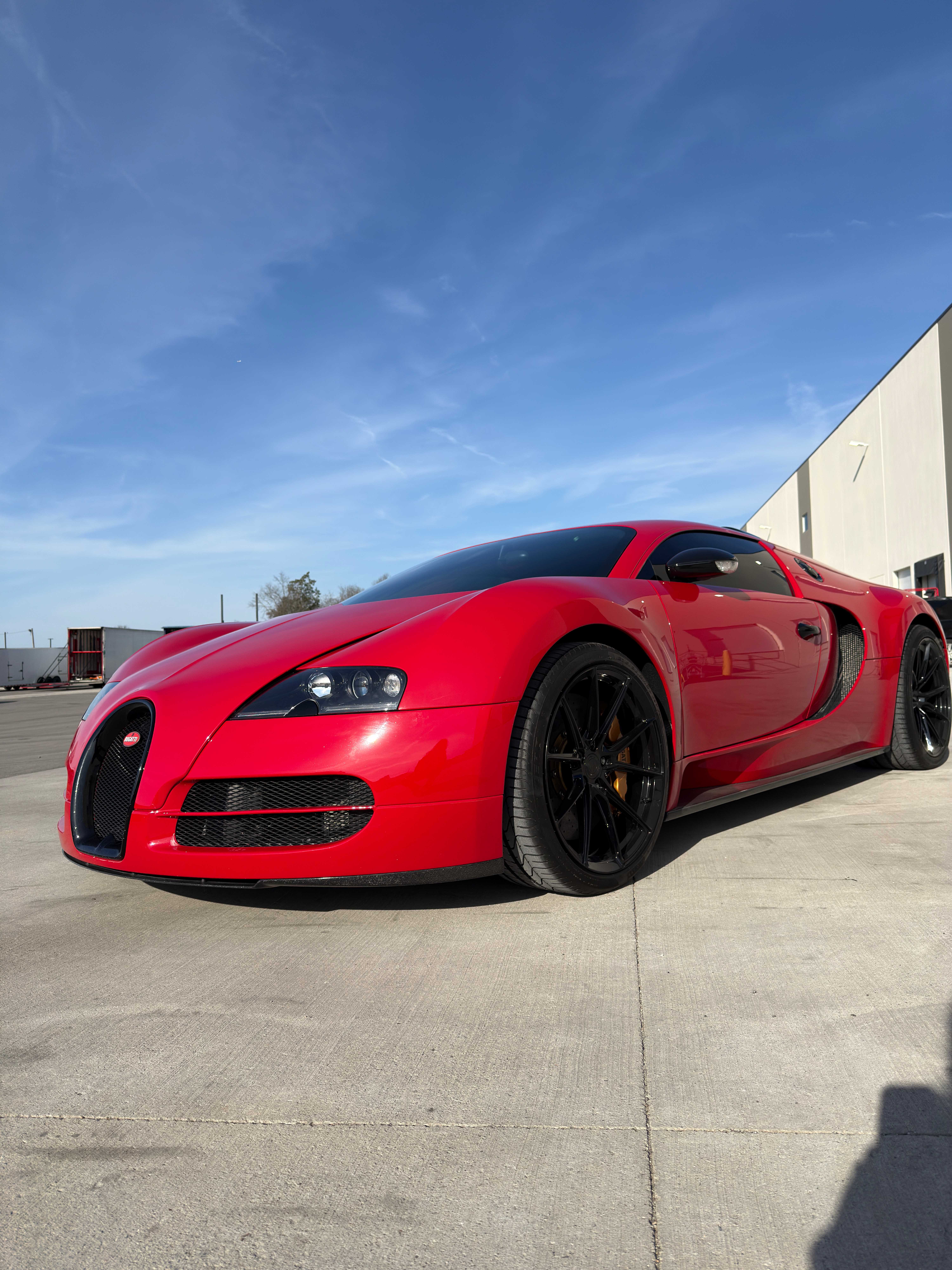 Bugatti Veyron Super Sport in red at dramatic low angle against blue sky