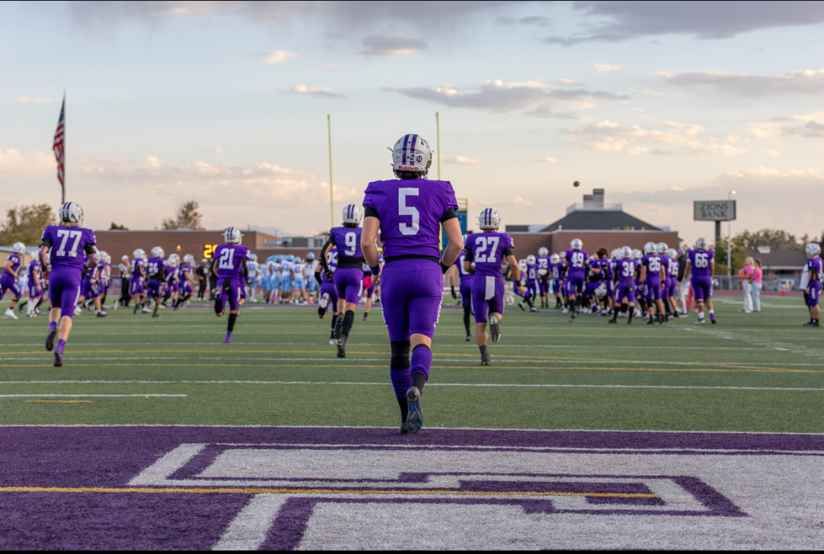 Gavin walking onto field at sunset with team