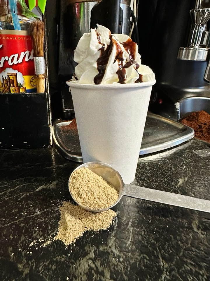 Whipped cream topped drink with chocolate drizzle