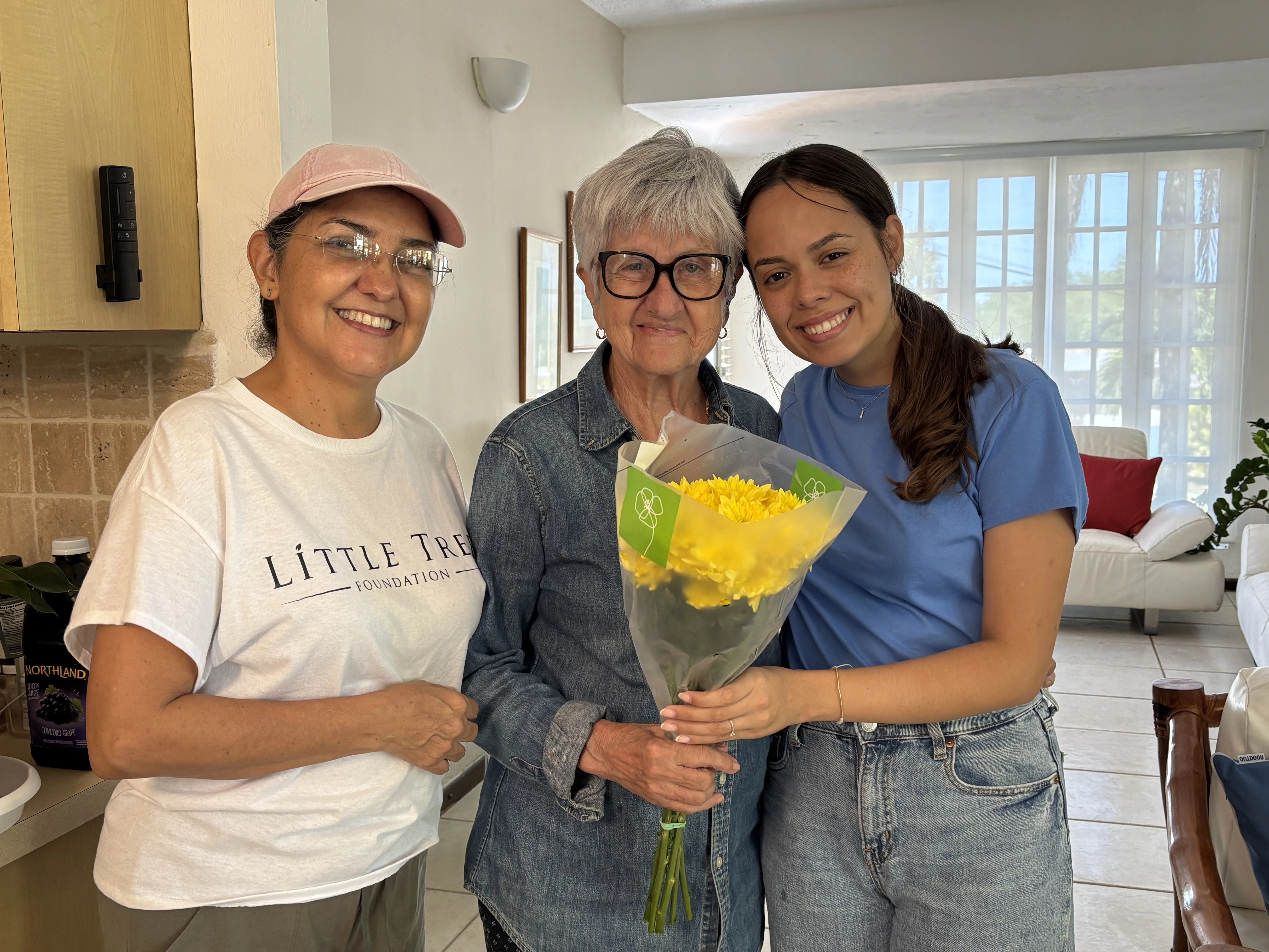 Voluntarias jóvenes compartiendo flores con adulta mayor