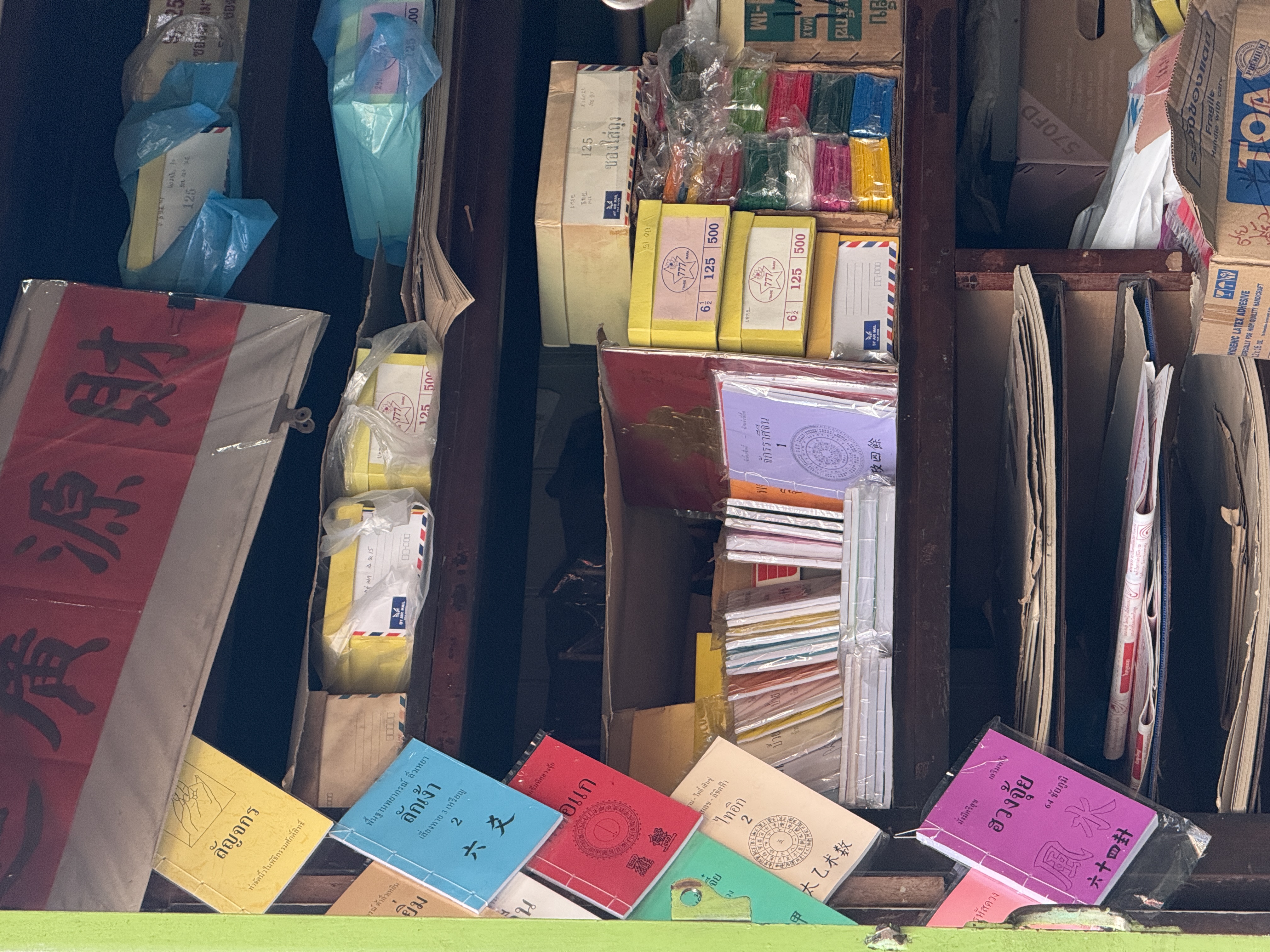 Colorful Thai shop shelves with papers and envelopes