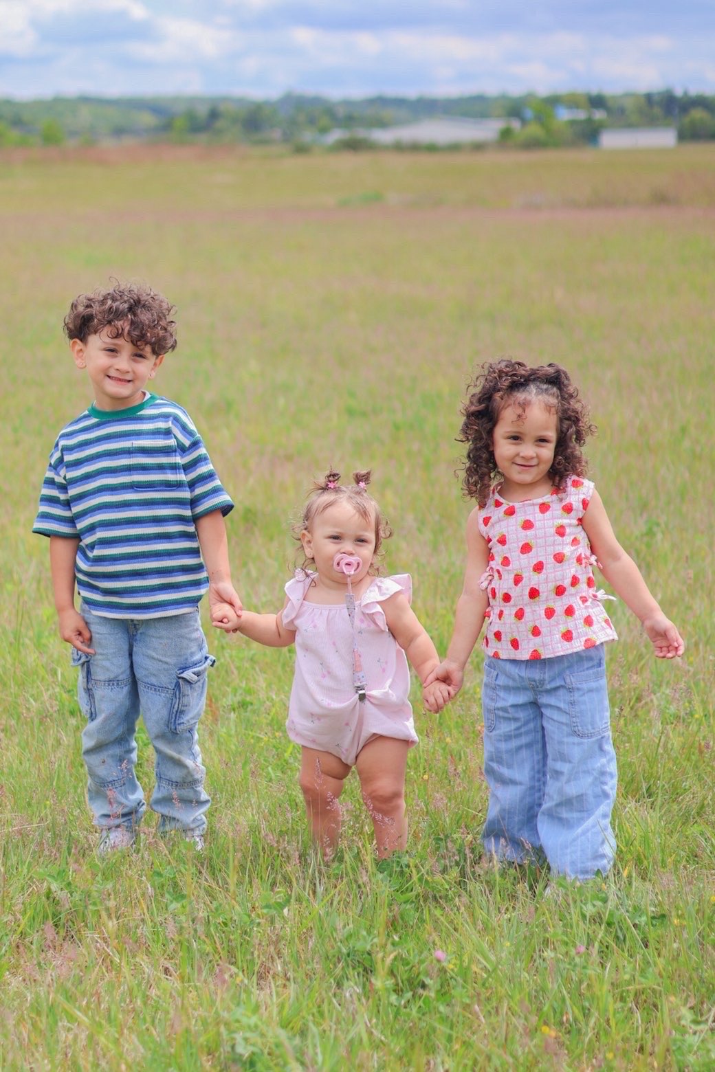 Children holding hands in a meadow