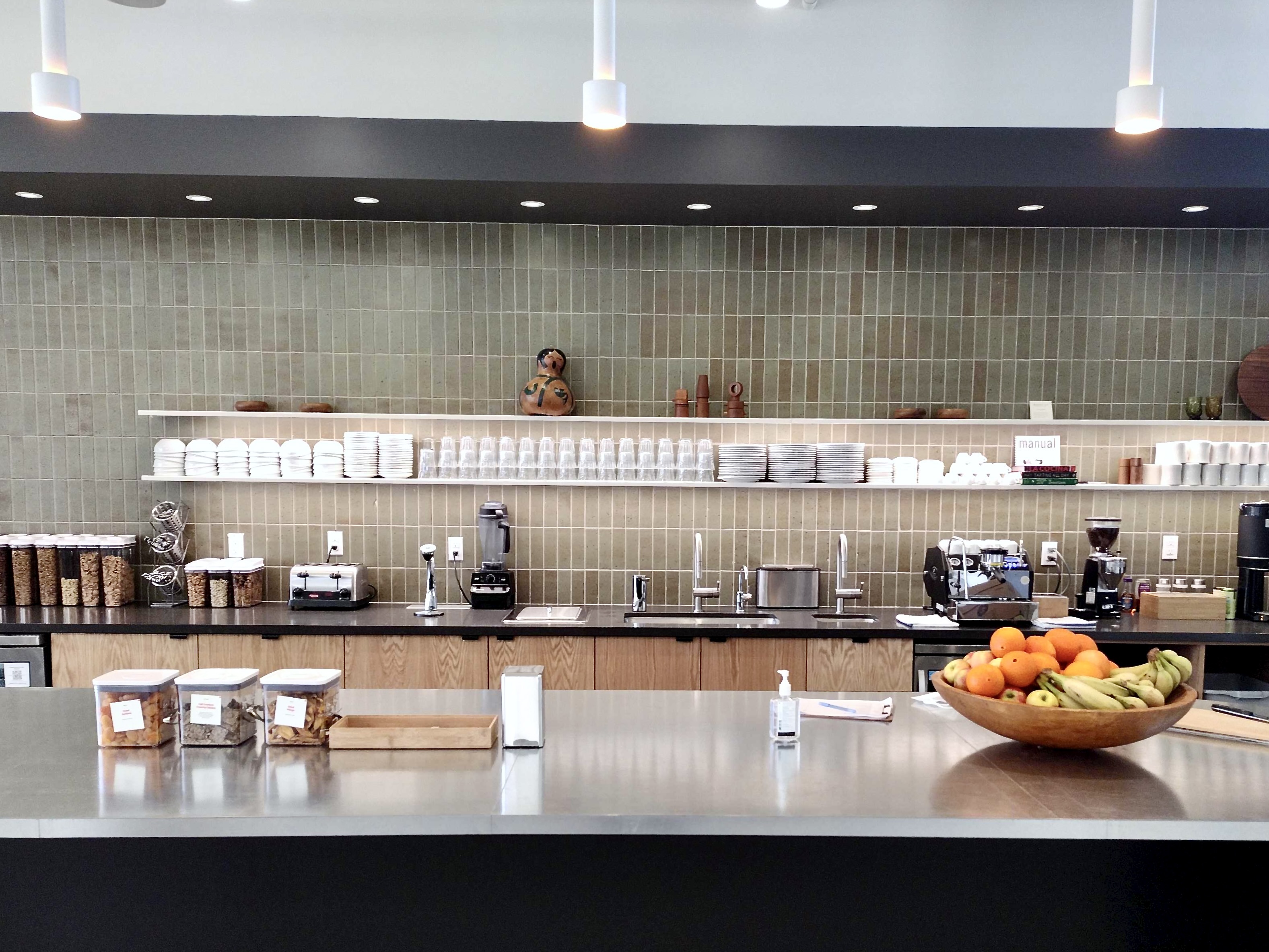Just Fare designed commercial kitchen with sage green tile backsplash, open shelving, and oak cabinetry