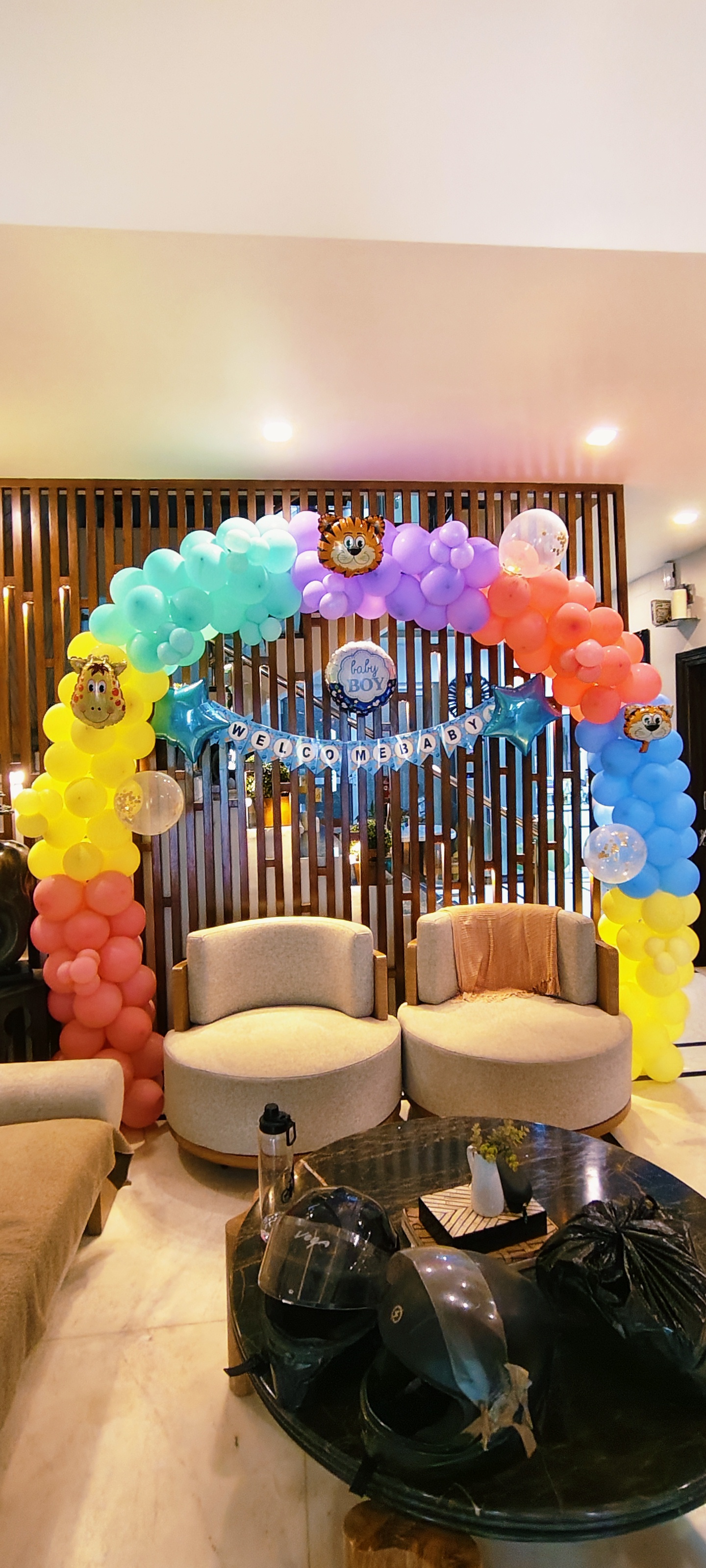 Rainbow colored balloon arch with jungle animals for baby welcome