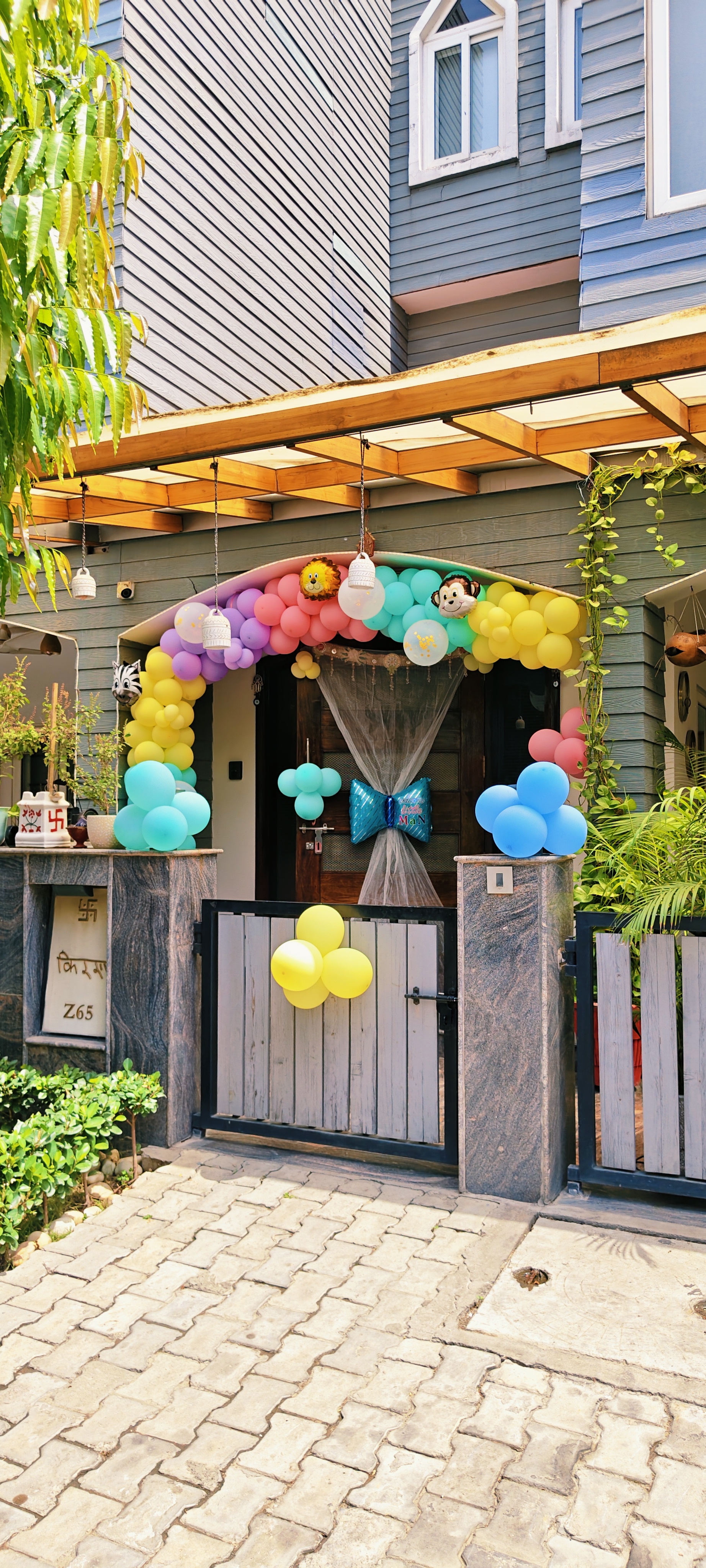 Colorful jungle theme balloon arch at house entrance with animal balloons