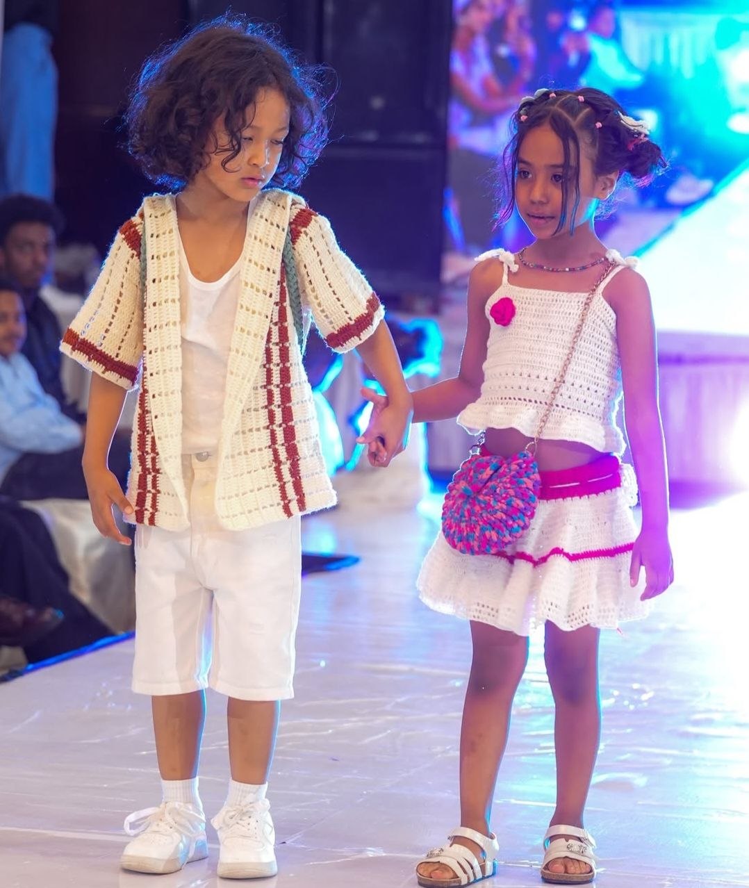 Two children walking hand in hand on a runway