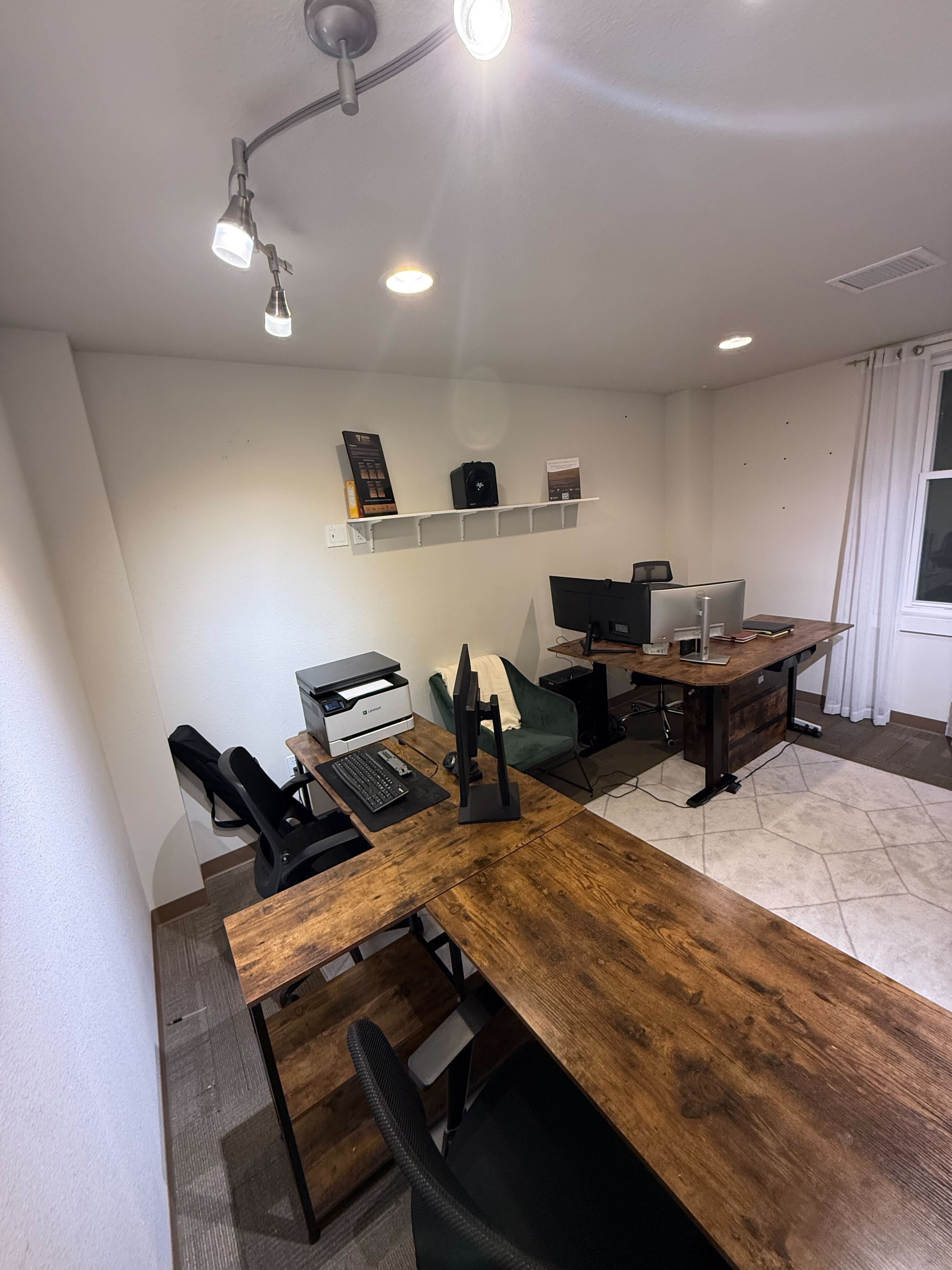 L-shaped wooden desks with monitors and printer
