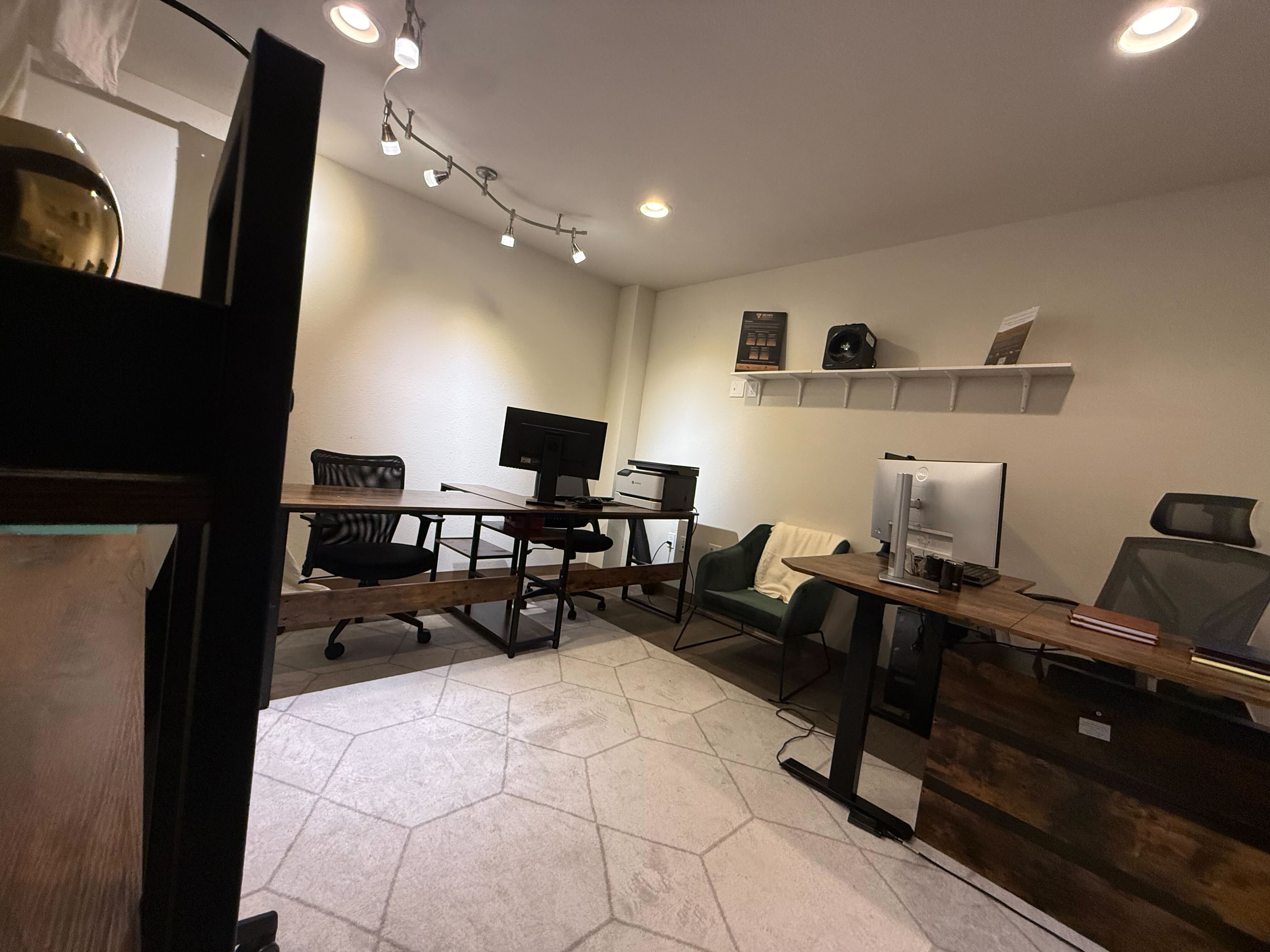 Another angle of workspace with standing desk and green accent chair