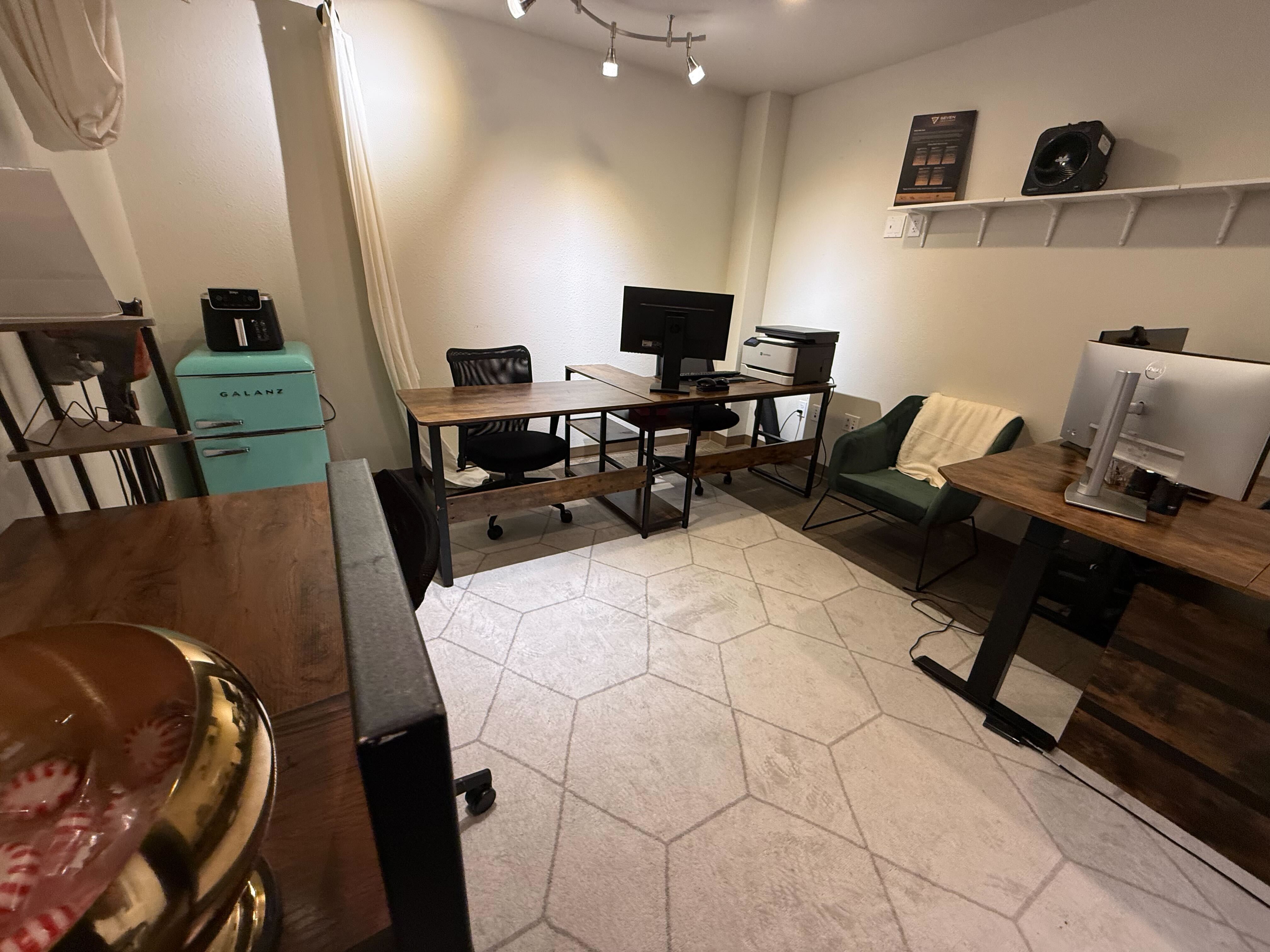 Coworking space overview with multiple workstations and standing desks