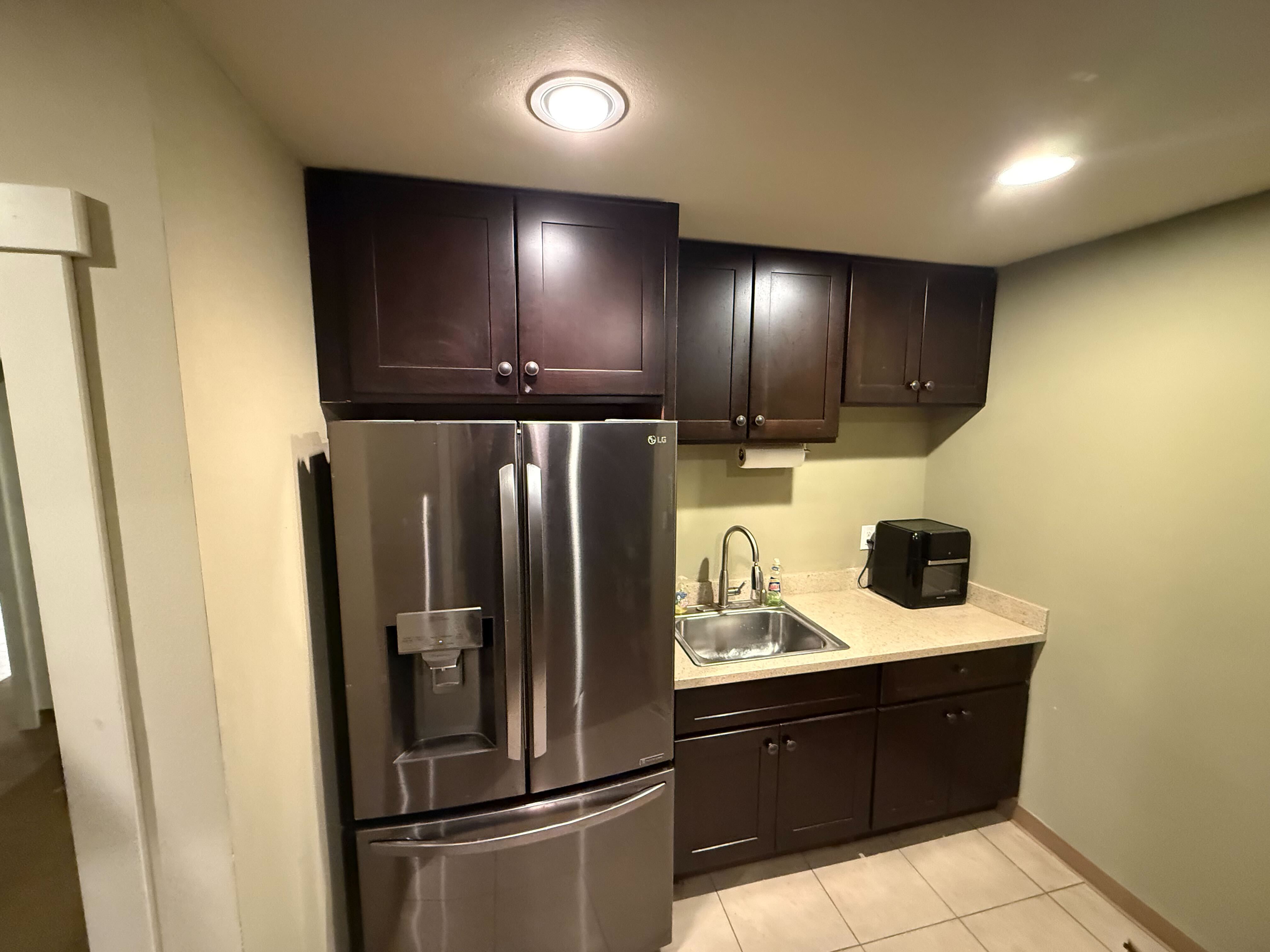Kitchenette with stainless steel refrigerator, sink, and appliances